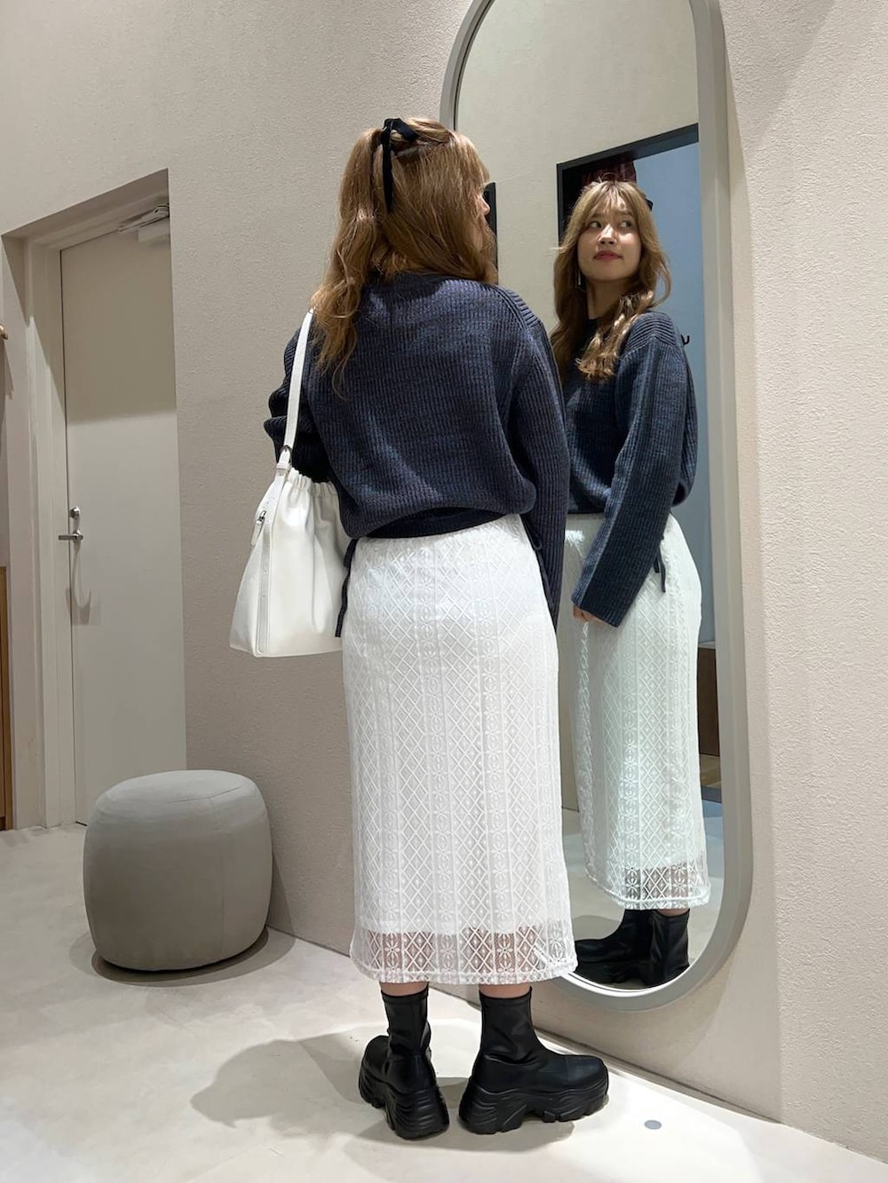 ブラック系のブーツ、ホワイト系のショルダーバッグ、ブルー系のワンピースを着用したレディースの秋コーディネートの3枚目の写真