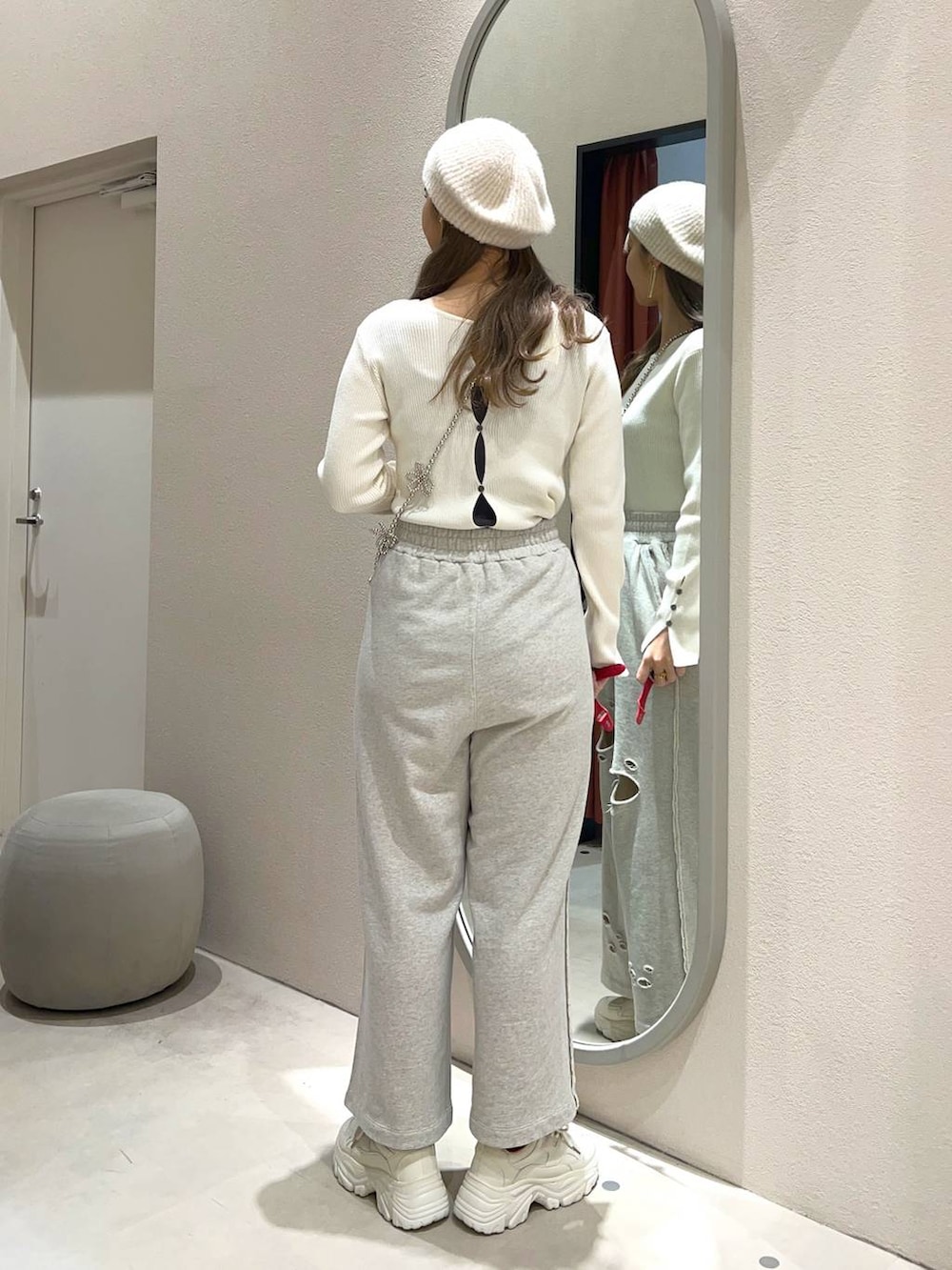 ホワイト系のスニーカー、ホワイト系のニット/セーター、グレー系のスウェットパンツを着用したレディースの冬コーディネートの3枚目の写真