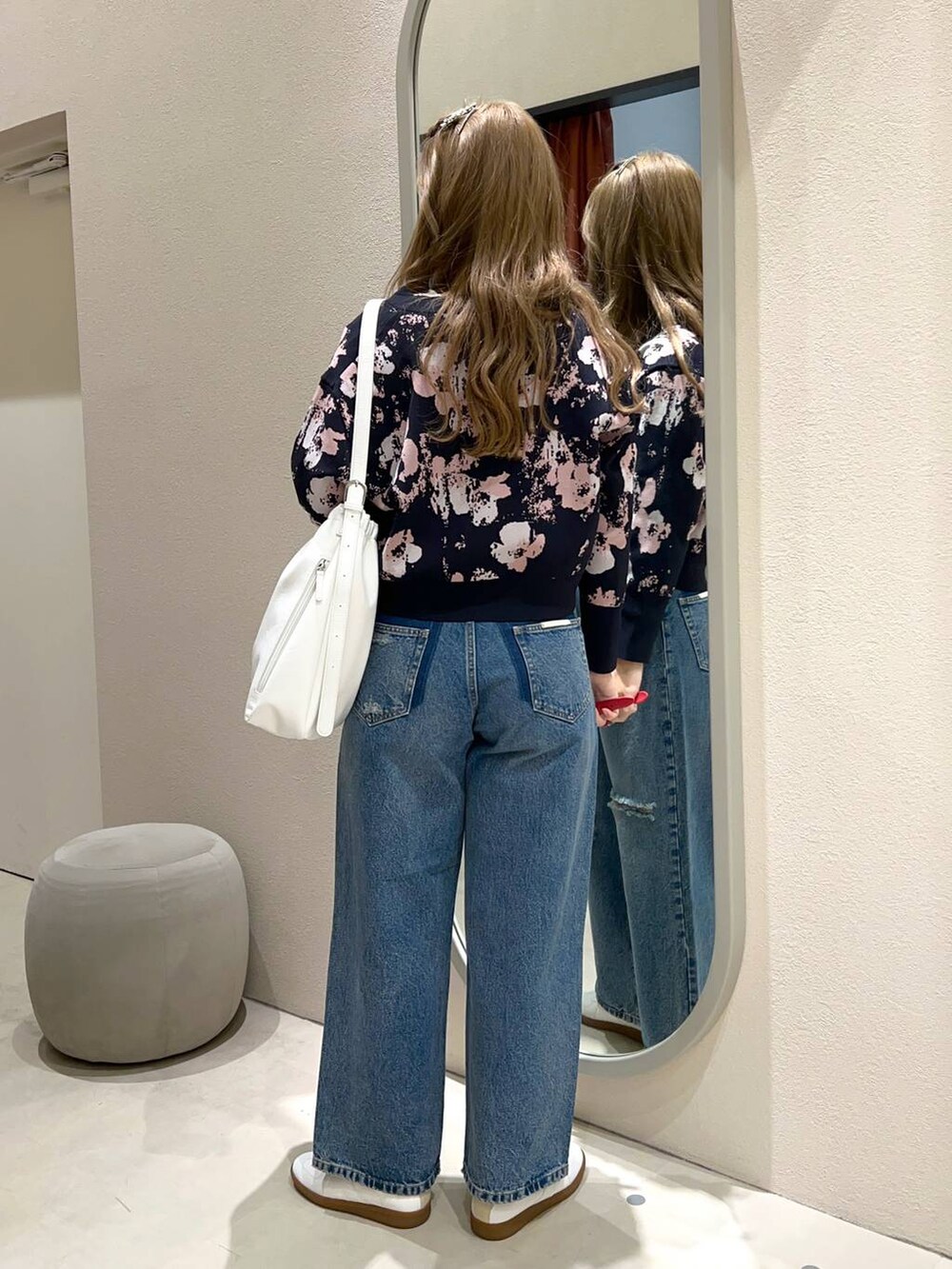 ブラウン系のショルダーバッグ、ブルー系のデニムパンツ、ベージュ系のTシャツ/カットソーを着用したレディースの冬コーディネートの3枚目の写真