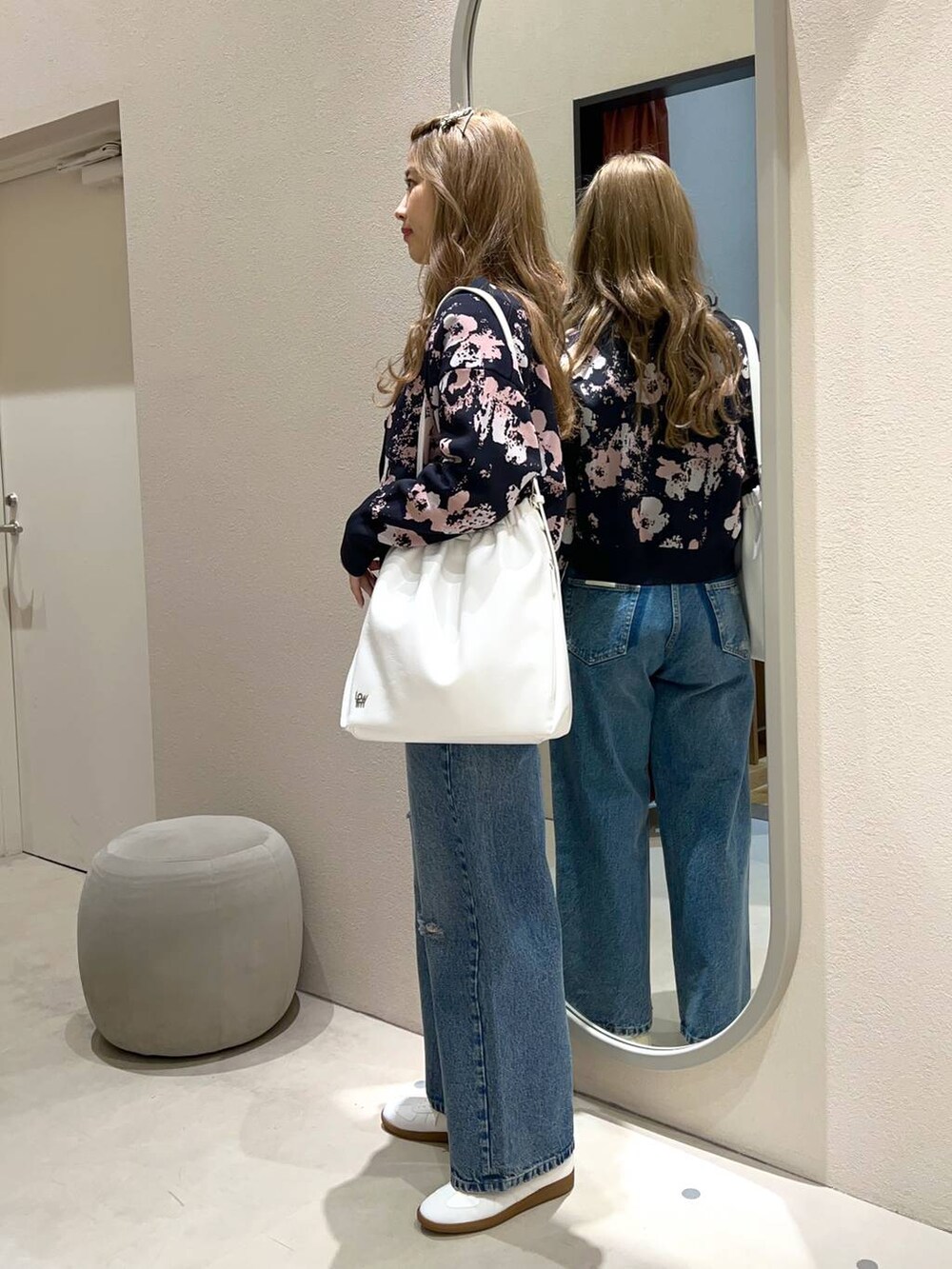 ブラウン系のショルダーバッグ、ブルー系のデニムパンツ、ベージュ系のTシャツ/カットソーを着用したレディースの冬コーディネートの2枚目の写真