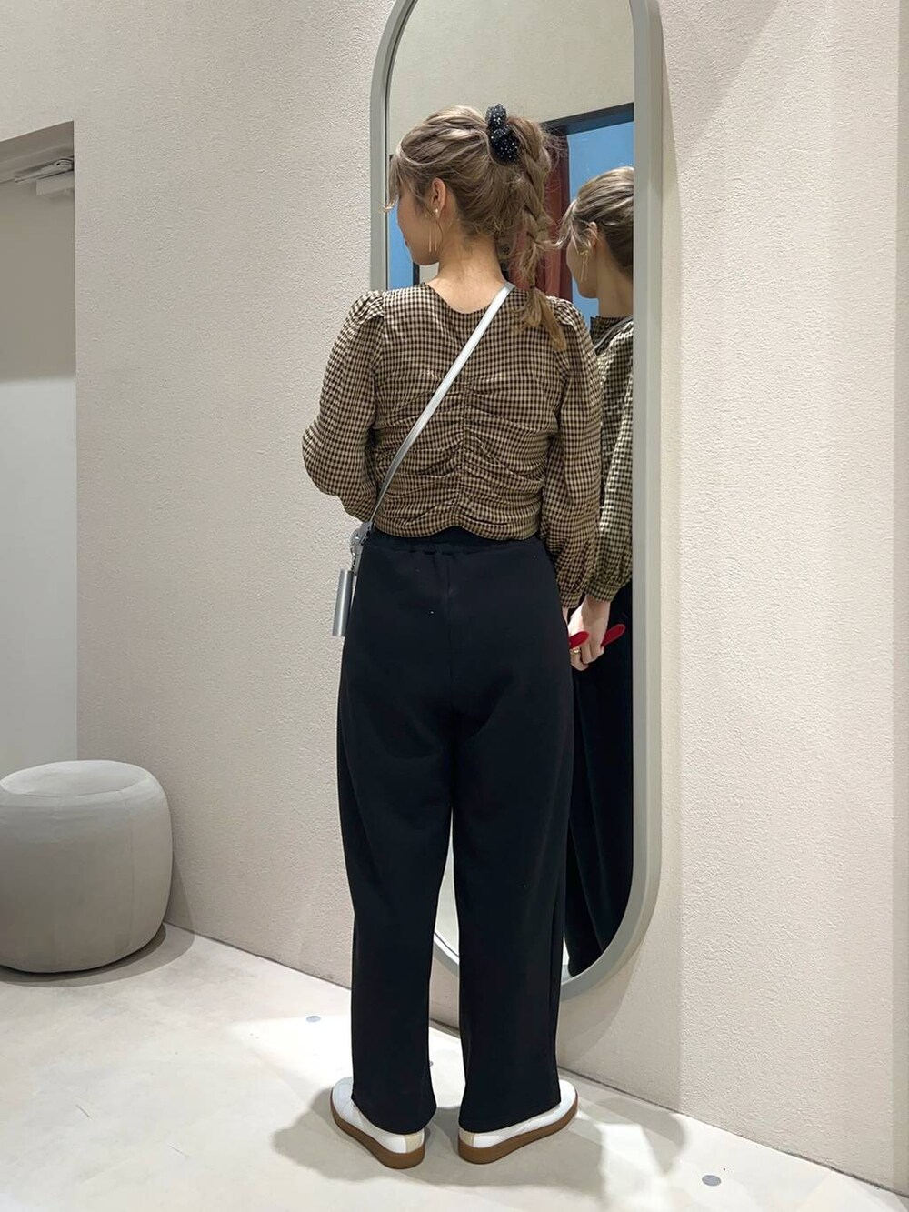 シルバー系のショルダーバッグ、ブラウン系のシャツ/ブラウス、ブラック系のスウェットパンツを着用したレディースの冬コーディネートの3枚目の写真