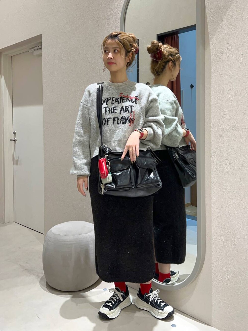ブラック系のその他アウター、その他のショルダーバッグ、グレー系のニット/セーターを着用したレディースの冬コーディネートの2枚目の写真