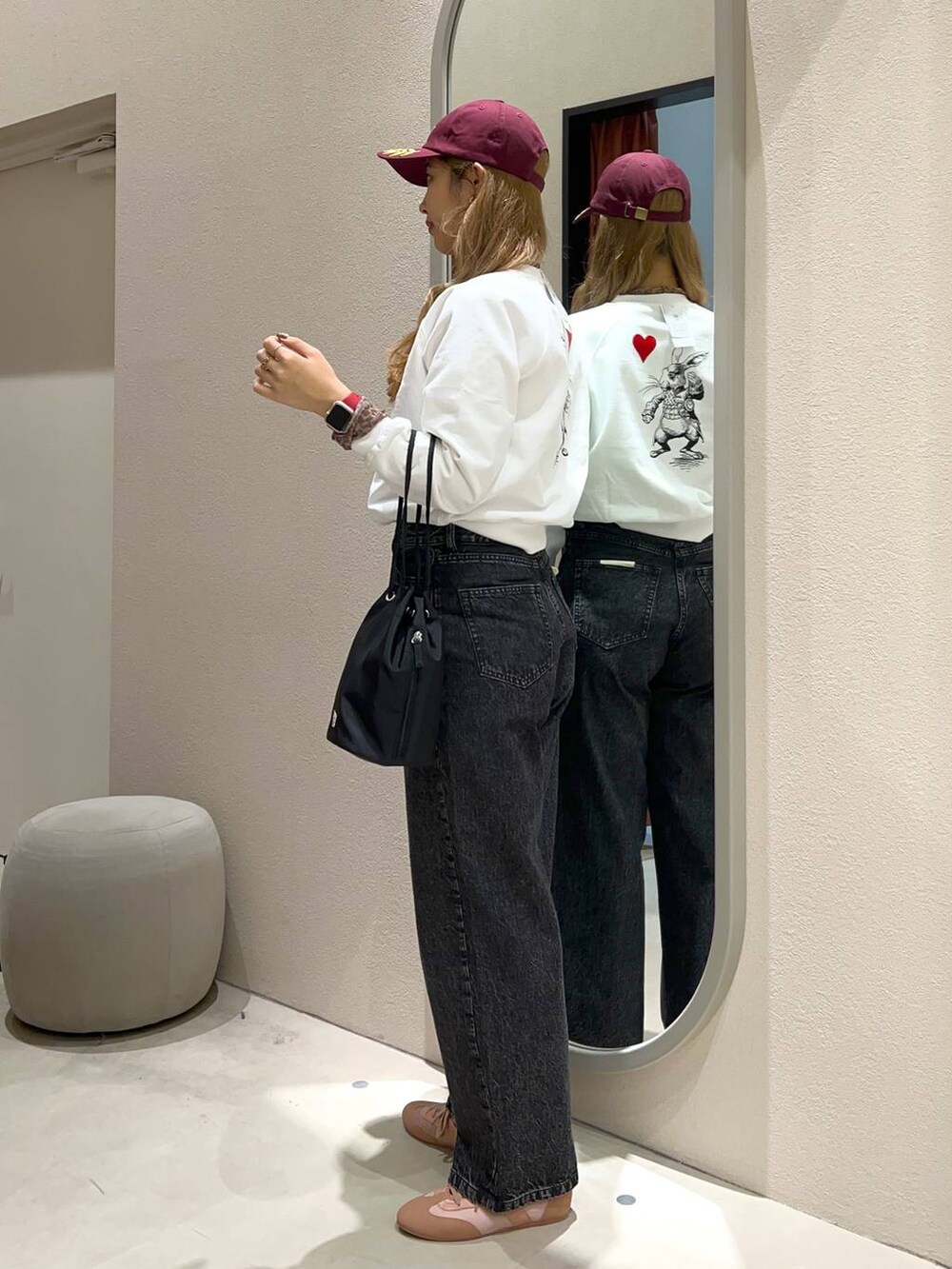 ブラック系のハンドバッグ、ブラウン系のTシャツ/カットソー、ピンク系のスニーカーを着用したレディースの冬コーディネートの2枚目の写真