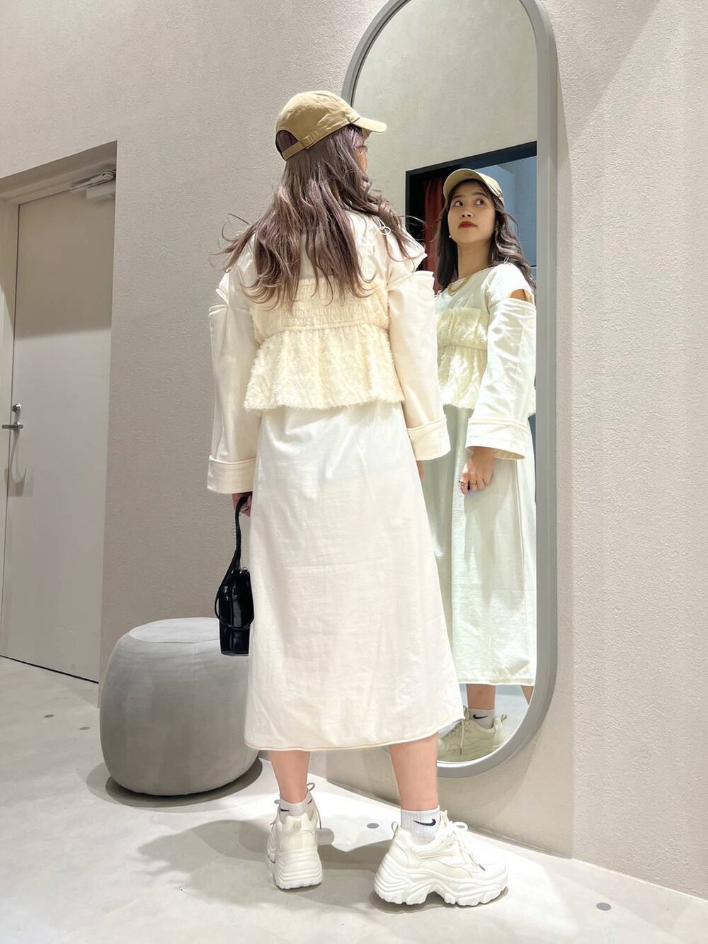 ブラック系のスマホグッズ、ベージュ系のキャップ、ゴールド系のリングを着用したレディースの春コーディネートの5枚目の写真