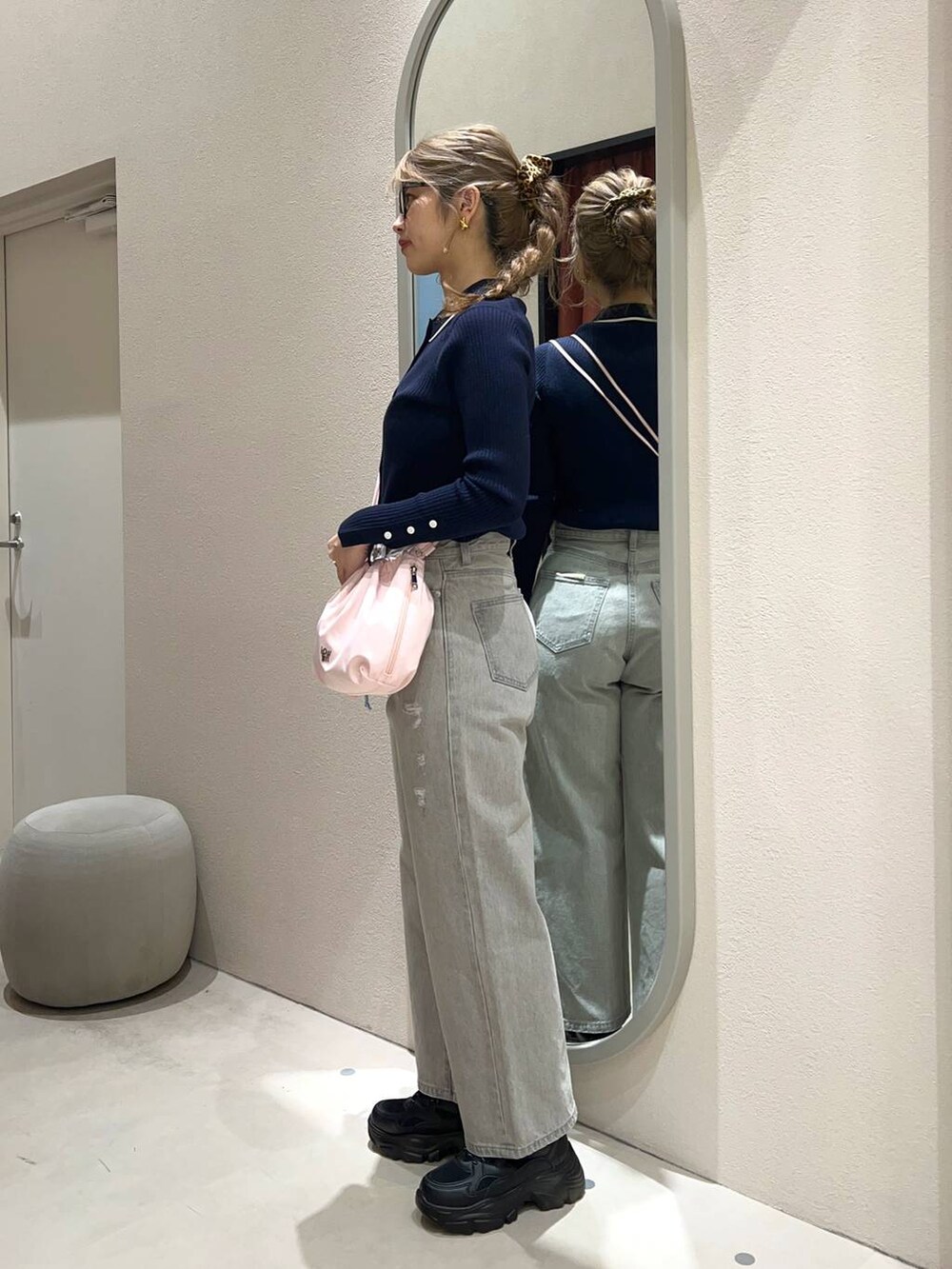 グレー系のデニムパンツ、ブラック系のスニーカー、ピンク系のショルダーバッグを着用したレディースの冬コーディネートの3枚目の写真