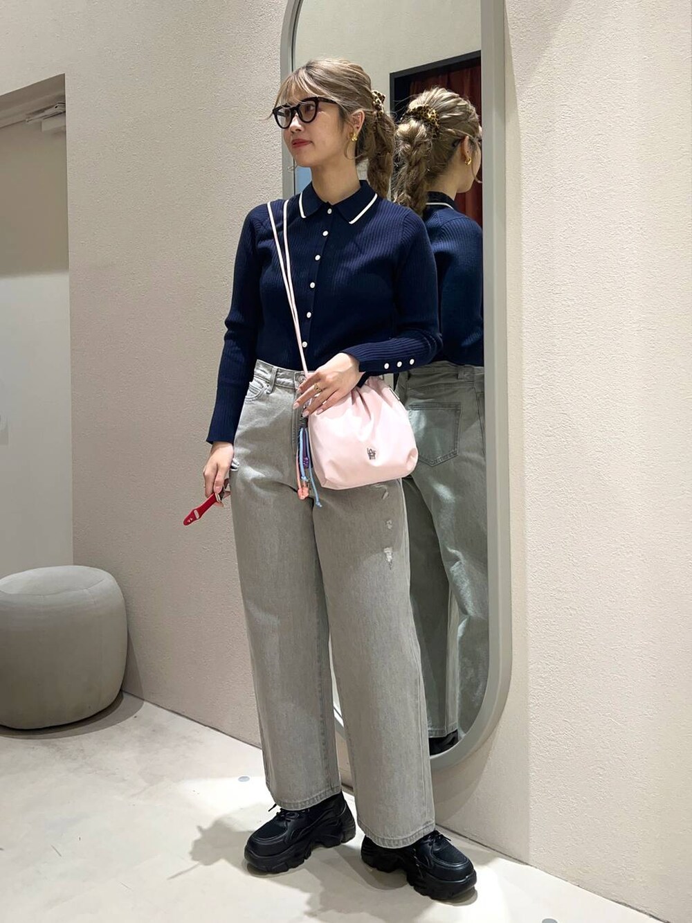 グレー系のデニムパンツ、ブラック系のスニーカー、ピンク系のショルダーバッグを着用したレディースの冬コーディネートの2枚目の写真