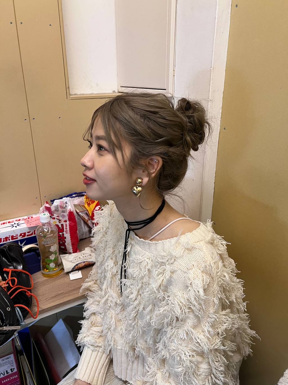 ホワイト系のスカート、ホワイト系のカーディガン/ボレロ、ベージュ系のスマホグッズを着用したレディースの冬コーディネートの2枚目の写真