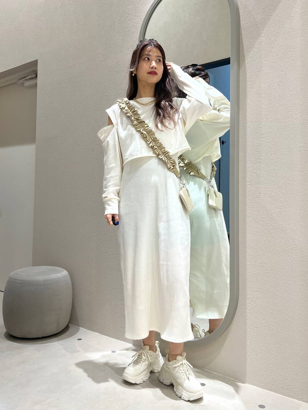 ホワイト系の財布、ベージュ系のスマホグッズ、ベージュ系のネックレスを着用したレディースの冬コーディネートの2枚目の写真