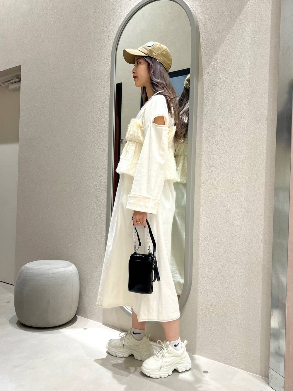 ブラック系のスマホグッズ、ベージュ系のキャップ、ゴールド系のリングを着用したレディースの春コーディネートの4枚目の写真