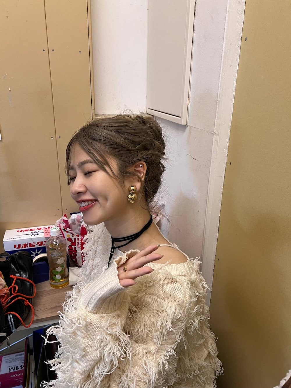 ホワイト系のスカート、ホワイト系のカーディガン/ボレロ、ベージュ系のスマホグッズを着用したレディースの冬コーディネートの3枚目の写真