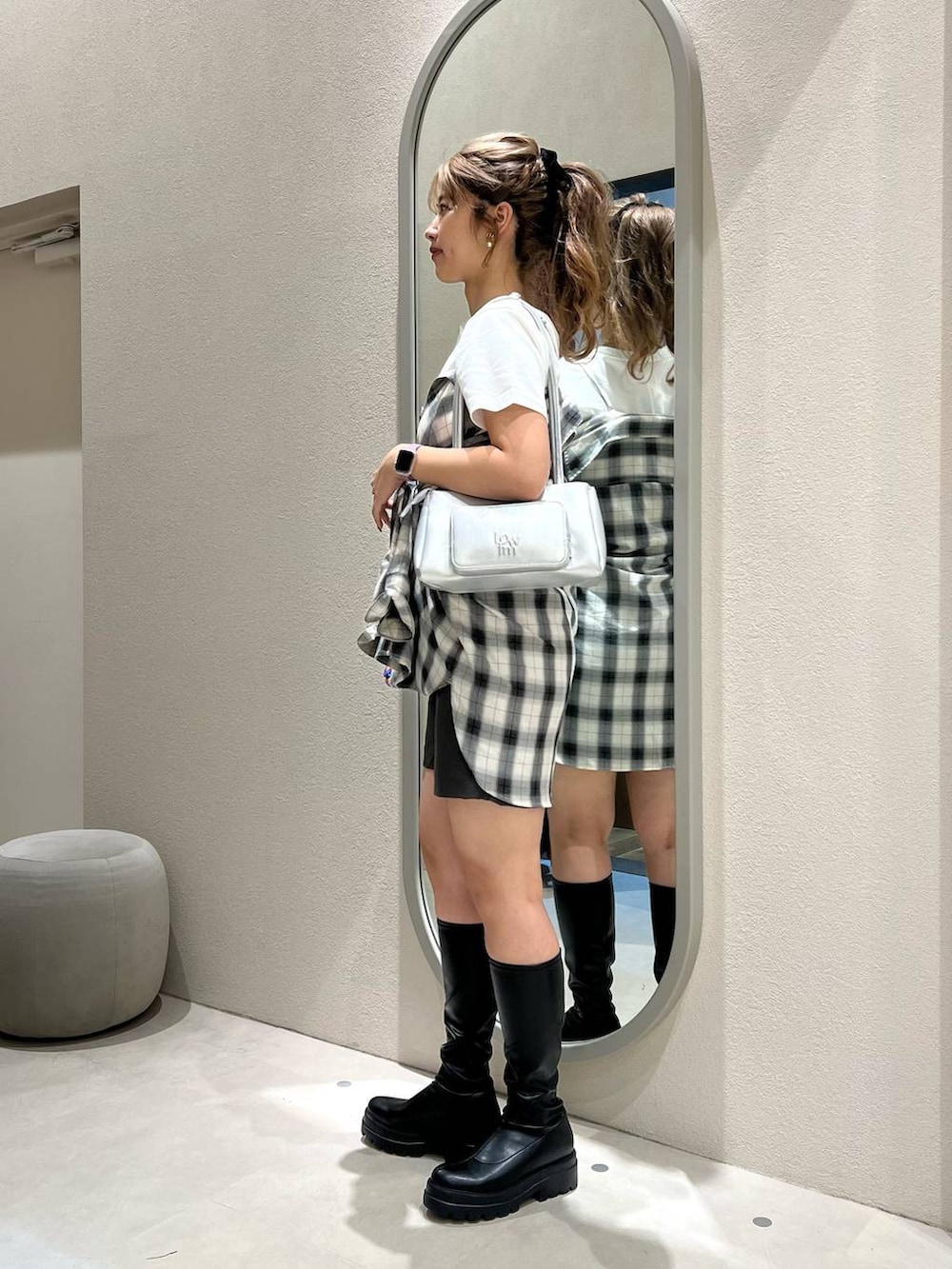 ホワイト系のシャツ/ブラウス、ブラック系のブーツ、ピンク系のショルダーバッグを着用したレディースの秋コーディネートの2枚目の写真