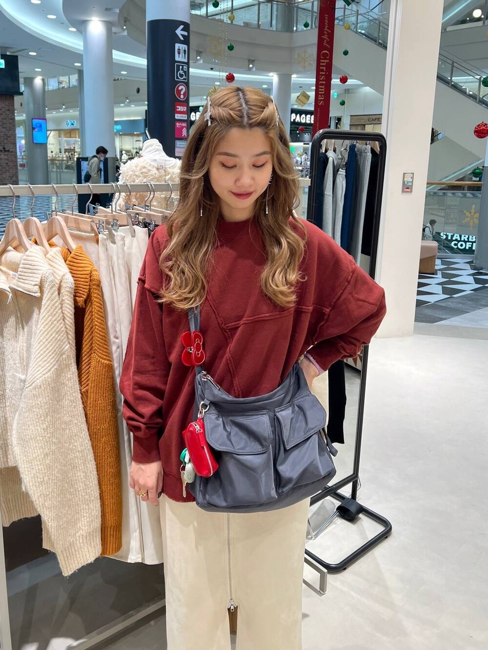 ブラック系のブーツ、グレー系のショルダーバッグ、ホワイト系のスカートを着用したレディースの秋コーディネートの2枚目の写真