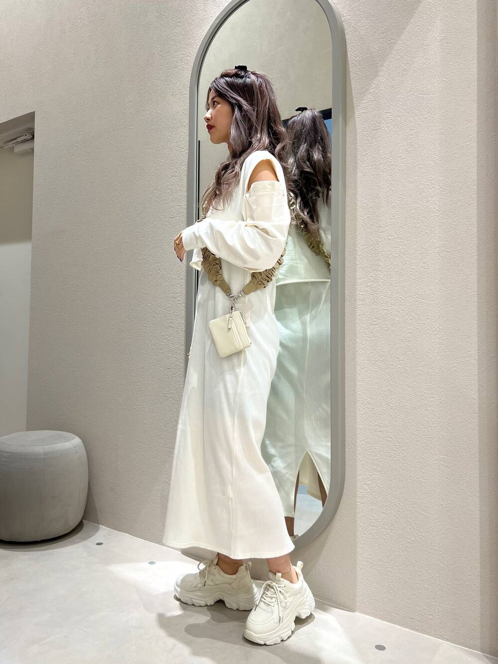 ホワイト系の財布、ベージュ系のスマホグッズ、ベージュ系のネックレスを着用したレディースの冬コーディネートの3枚目の写真