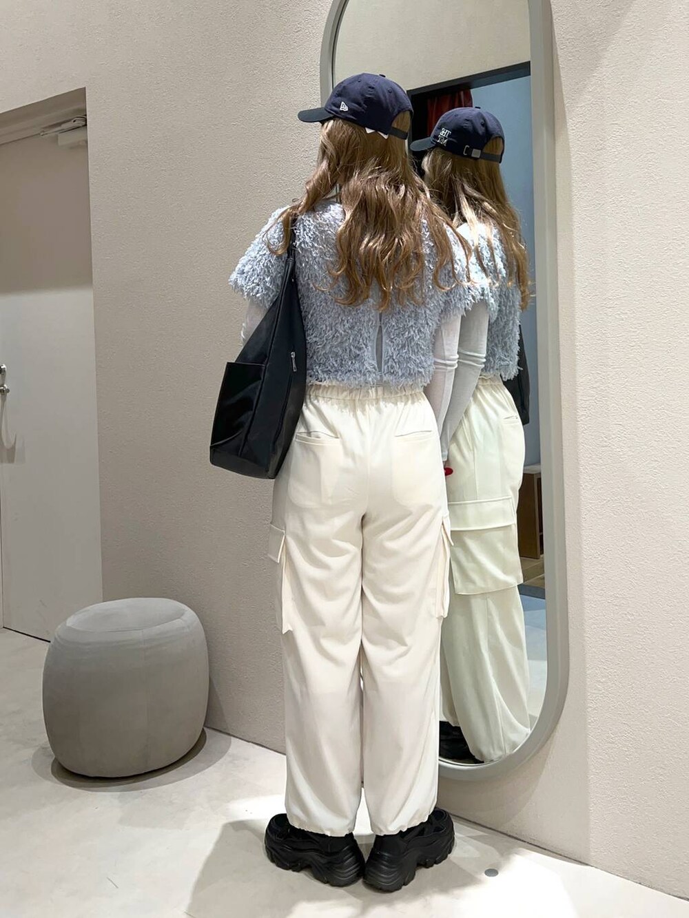 ブラック系のトートバッグ、ブラック系のスニーカー、ブルー系のTシャツ/カットソーを着用したレディースの冬コーディネートの3枚目の写真