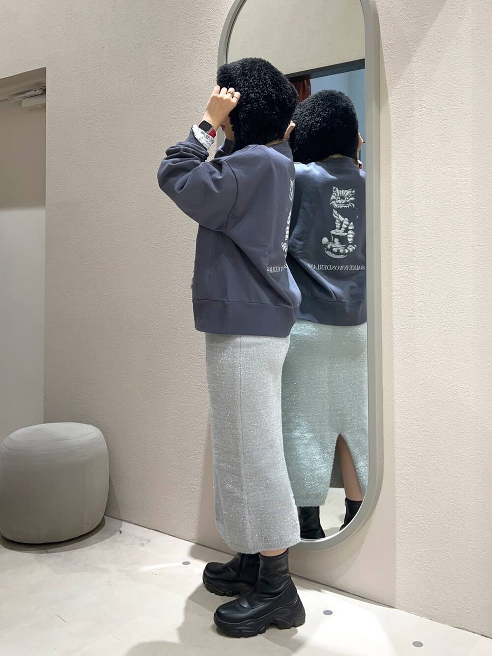 ブラック系のブーツ、グレー系のスカート、ホワイト系のTシャツ/カットソーを着用したレディースの冬コーディネートの2枚目の写真