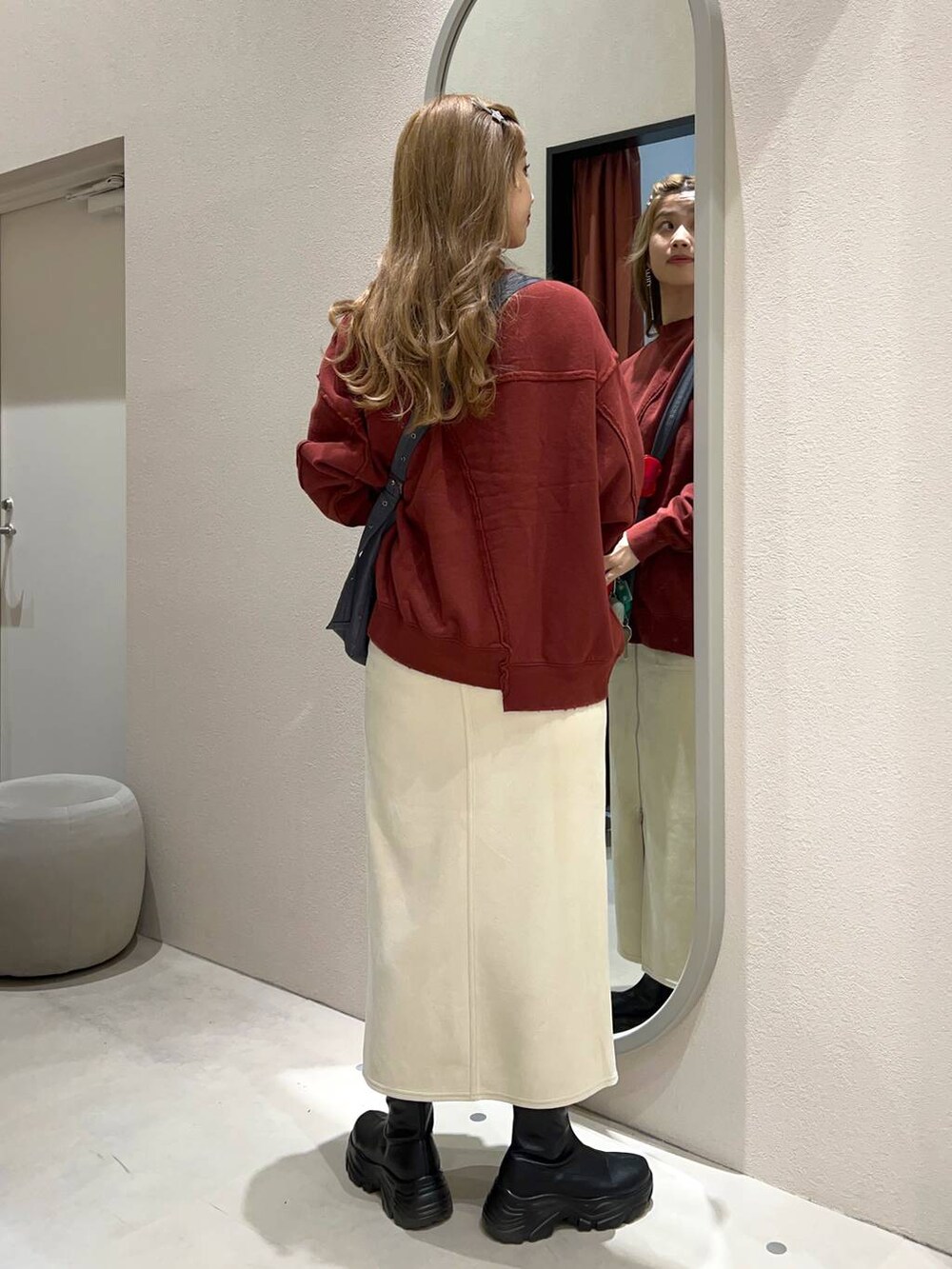 ブラック系のブーツ、グレー系のショルダーバッグ、ホワイト系のスカートを着用したレディースの秋コーディネートの4枚目の写真