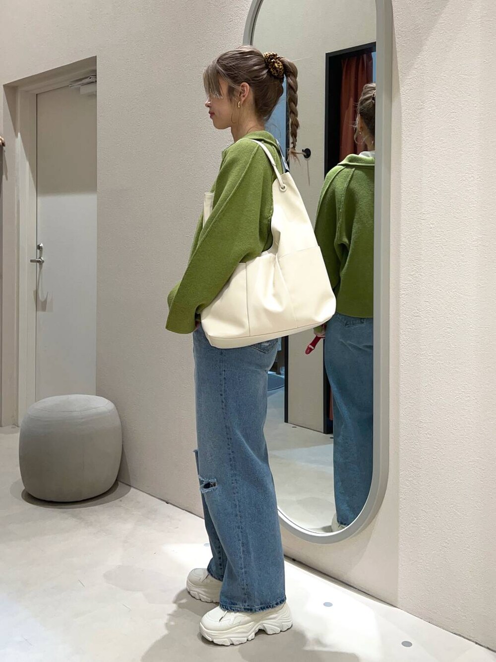 ホワイト系のTシャツ/カットソー、ブルー系のデニムパンツ、ホワイト系のトートバッグを着用したレディースの冬コーディネートの3枚目の写真