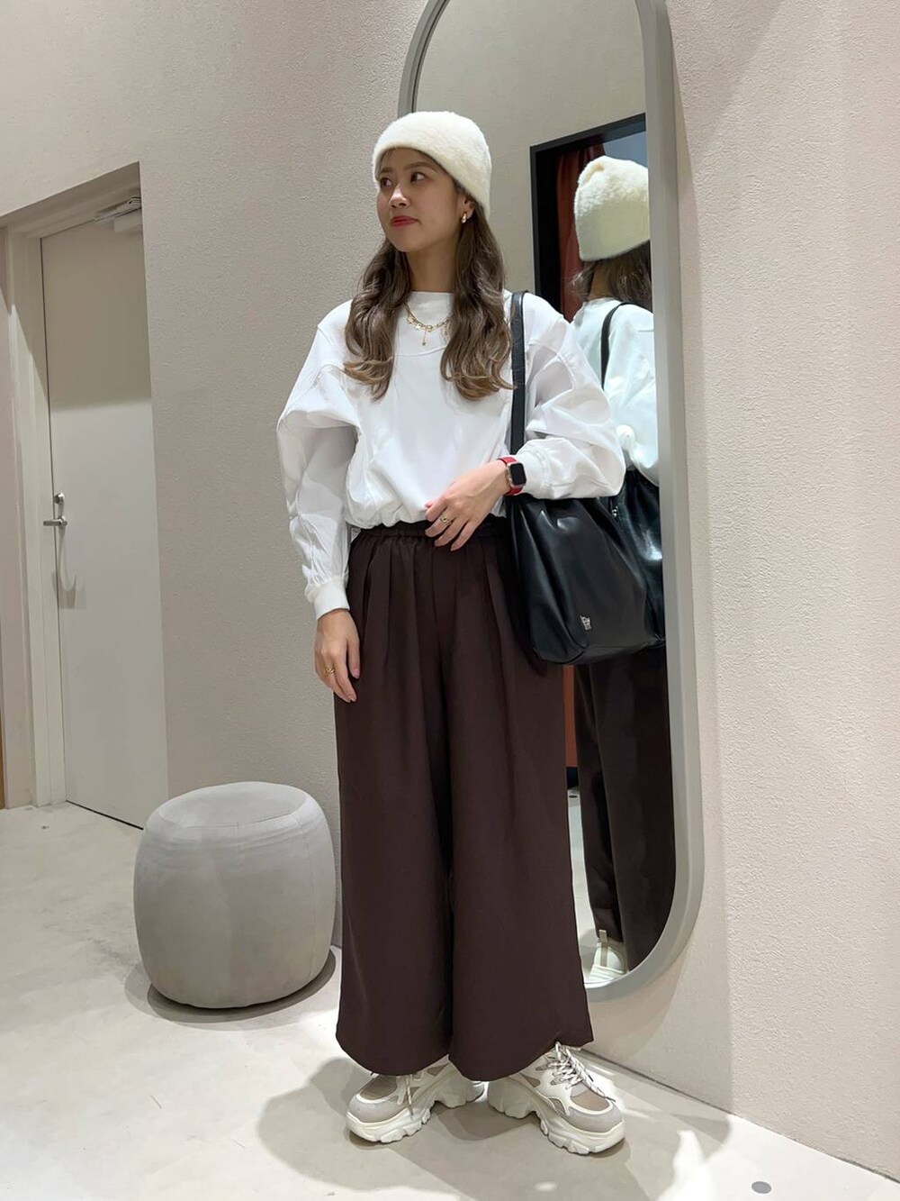 ホワイト系のショルダーバッグ、ブラウン系のその他パンツ、ベージュ系のスニーカーを着用したレディースの冬コーディネートの2枚目の写真