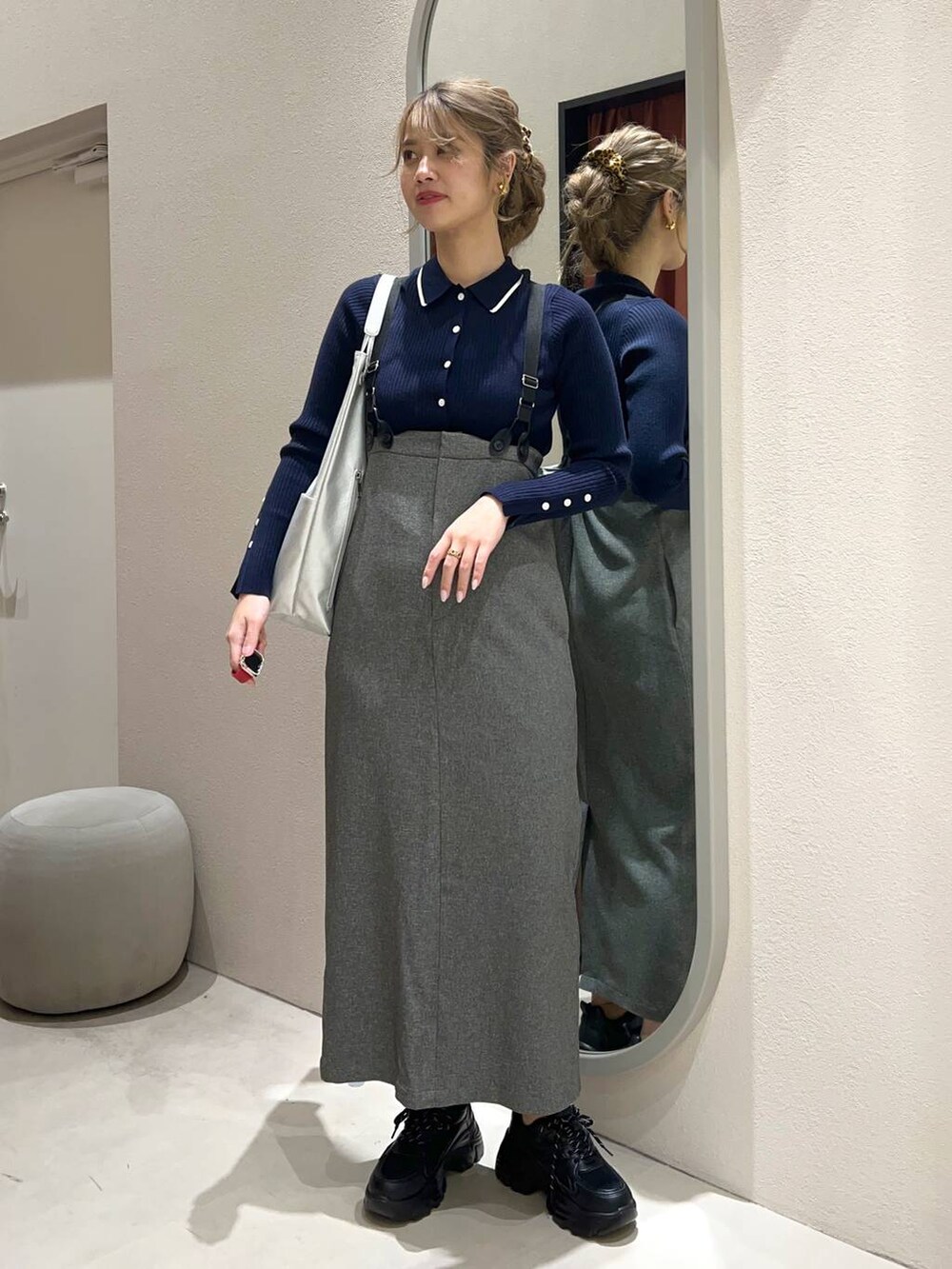 グレー系のワンピース、シルバー系のトートバッグ、ブルー系のカーディガン/ボレロを着用したレディースの冬コーディネートの2枚目の写真