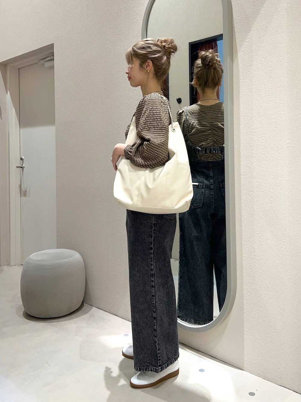 ブラック系のサロペット/オーバーオール、ホワイト系のトートバッグ、ホワイト系のスニーカーを着用したレディースの冬コーディネートの2枚目の写真