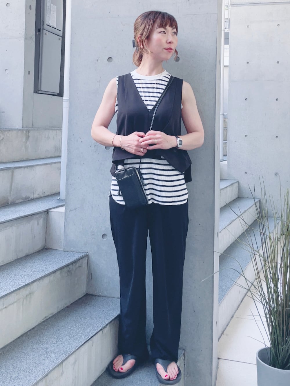 ホワイト系のTシャツ/カットソー、ブラック系のベスト、ブラック系のサンダルを着用したレディースの夏コーディネートの2枚目の写真