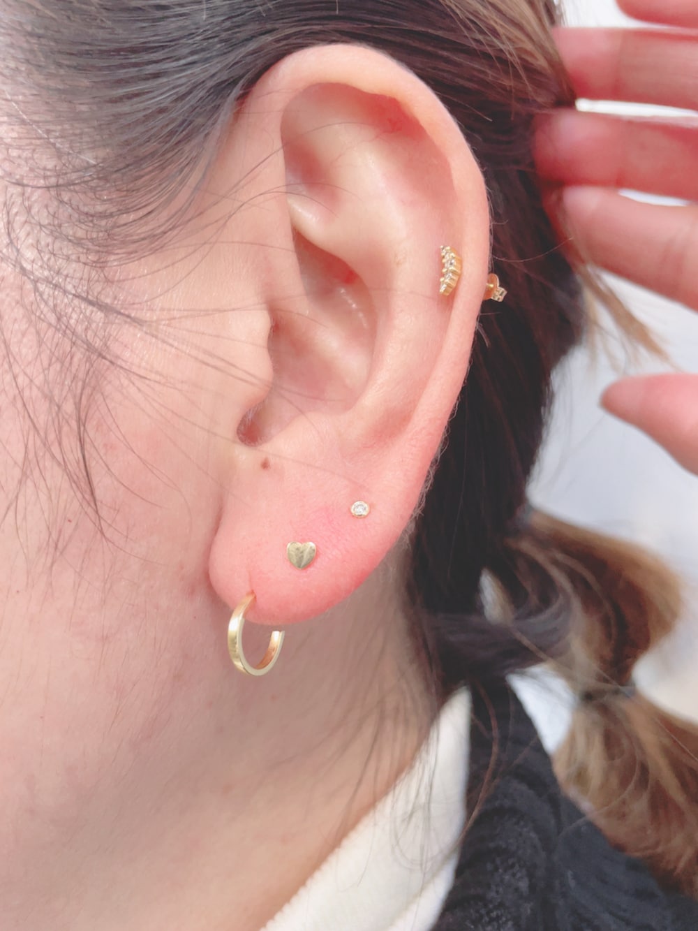 ブラック系のニット/セーター、ブラック系のハンドバッグ、ベージュ系のスニーカーを着用したレディースの秋コーディネートの3枚目の写真