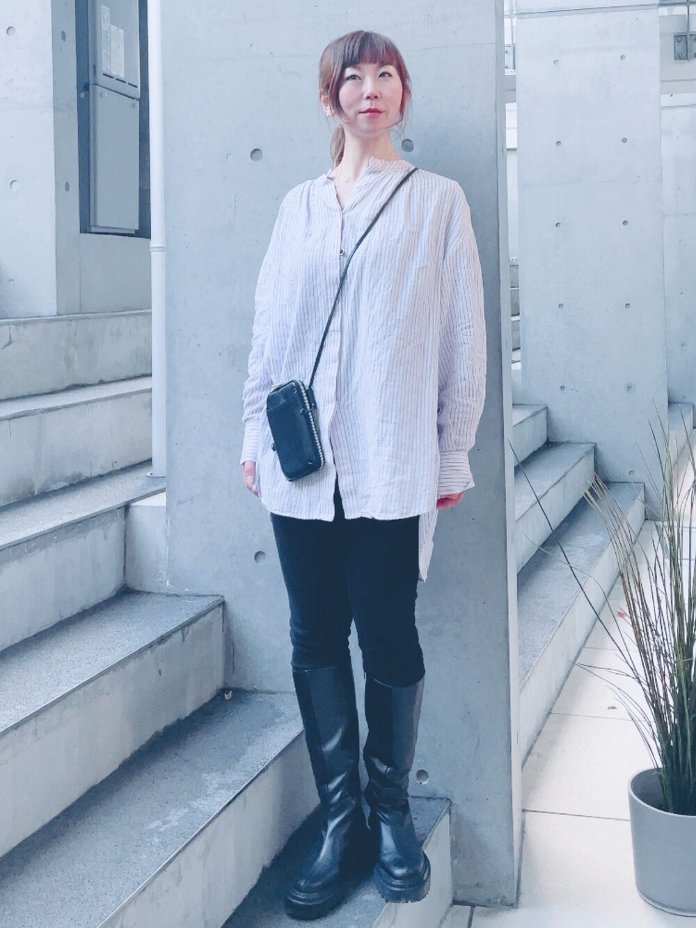 ピンク系のシャツ/ブラウス、ブラック系のブーツ、ブラック系のポーチを着用したレディースの春コーディネートの2枚目の写真