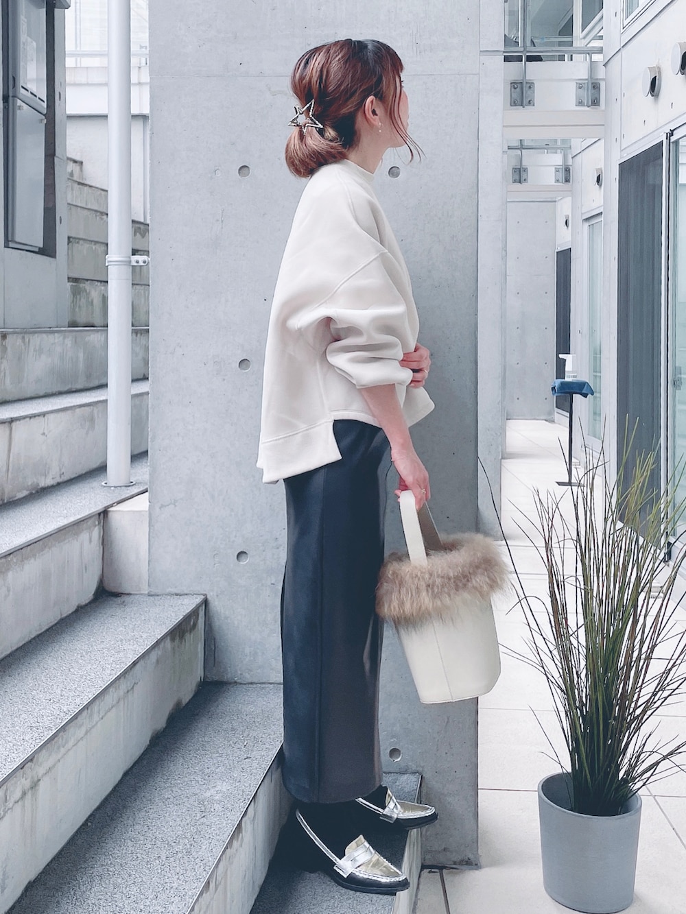 ホワイト系のスウェット、ブラック系のスカート、ホワイト系のショルダーバッグを着用したレディースの秋コーディネートの2枚目の写真