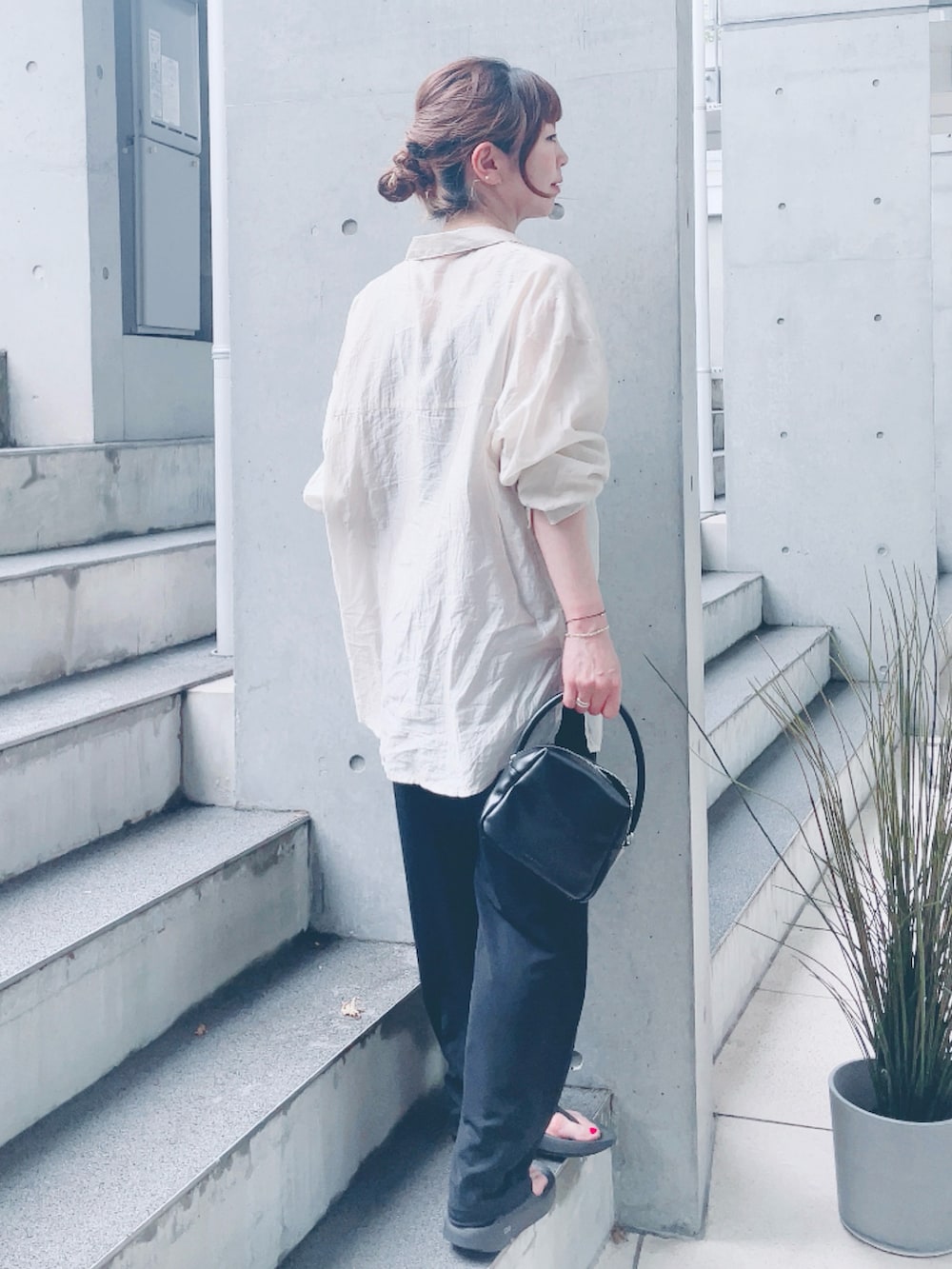 ベージュ系のシャツ/ブラウス、ブラック系のハンドバッグを着用したレディースの夏コーディネートの3枚目の写真