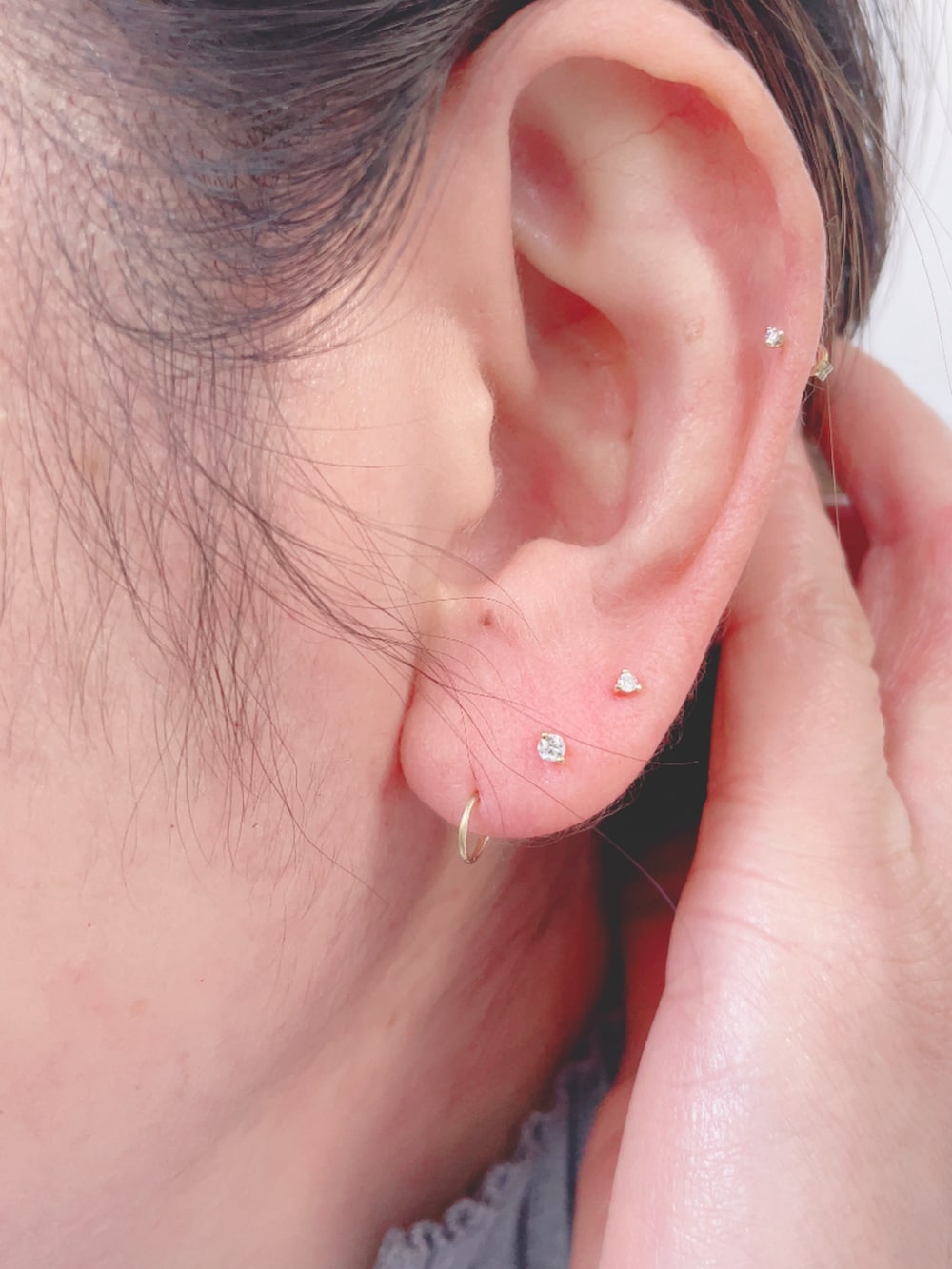 グレー系のニット/セーター、ホワイト系のバッグ、グレー系のスラックスを着用したレディースの冬コーディネートの4枚目の写真