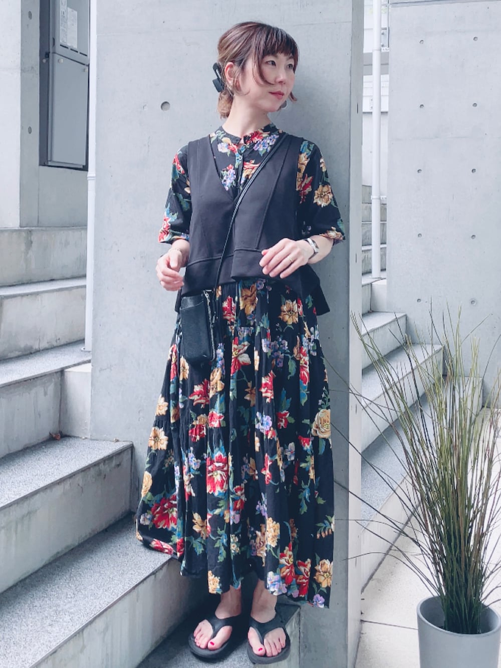 ブラック系のワンピース、ブラック系のベスト、ブラック系のサンダルを着用したレディースの夏コーディネートの2枚目の写真