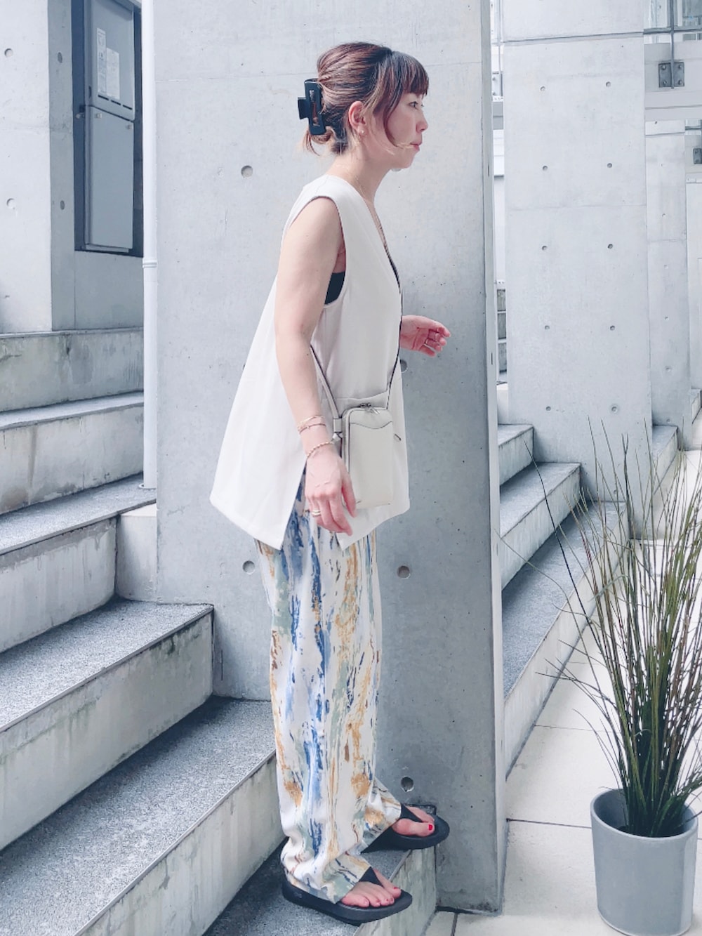 ベージュ系のベスト、ホワイト系のショルダーバッグ、ブラック系のサンダルを着用したレディースの夏コーディネートの3枚目の写真