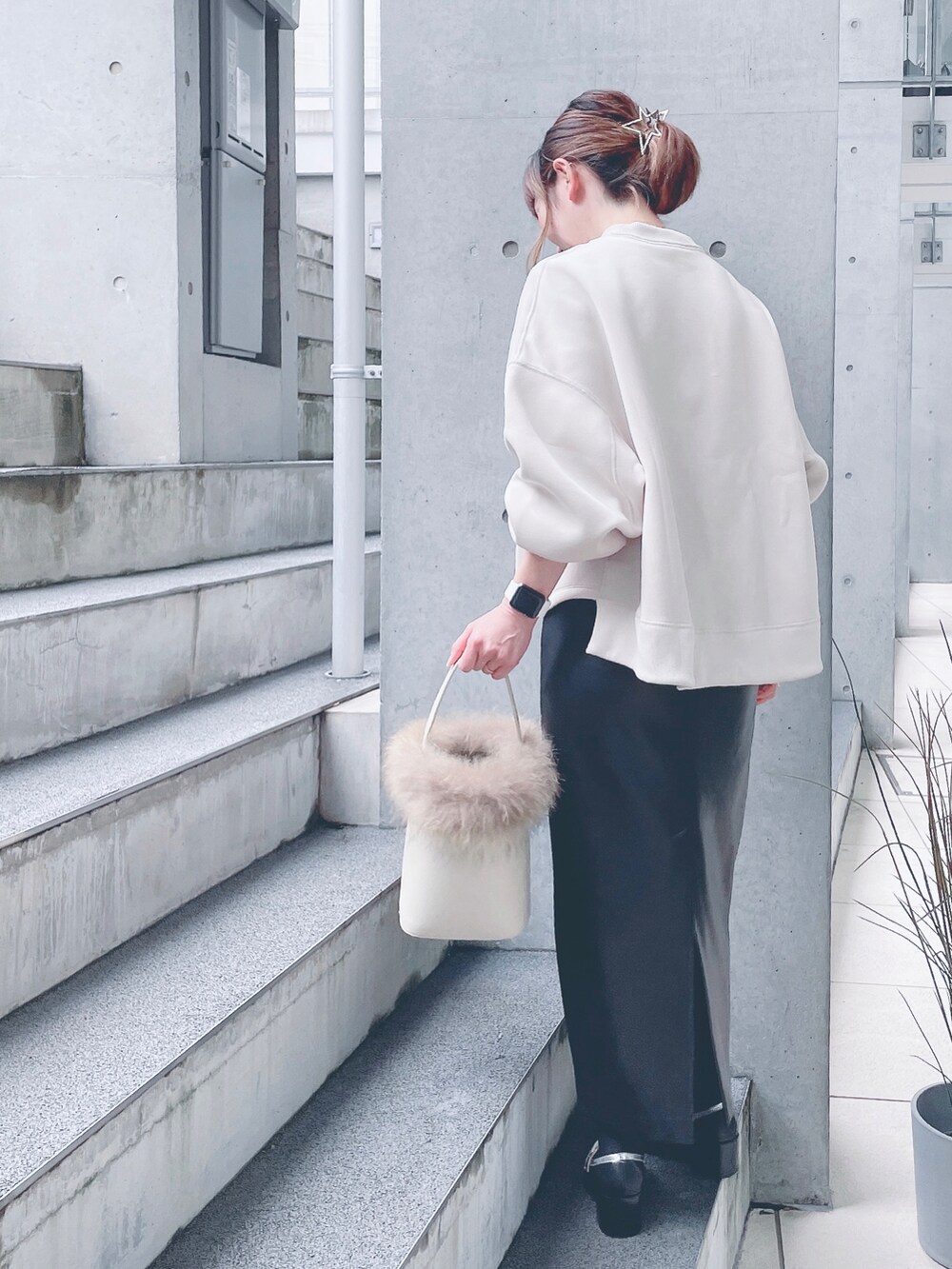 ホワイト系のスウェット、ブラック系のスカート、ホワイト系のショルダーバッグを着用したレディースの秋コーディネートの3枚目の写真