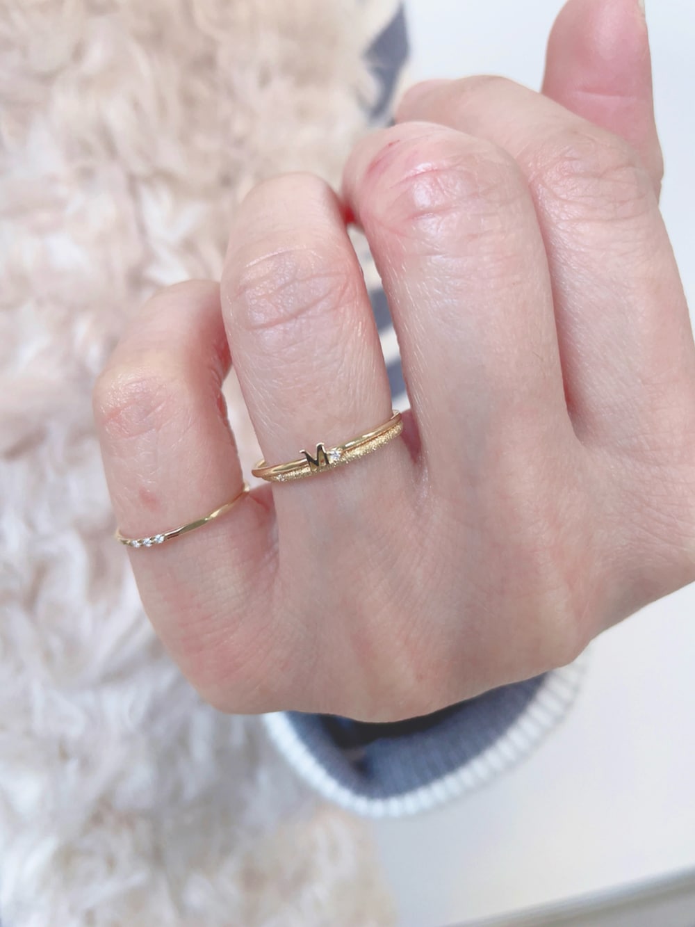 グレー系のニット/セーター、ブルー系のデニムパンツ、ホワイト系のショルダーバッグを着用したレディースの秋コーディネートの4枚目の写真