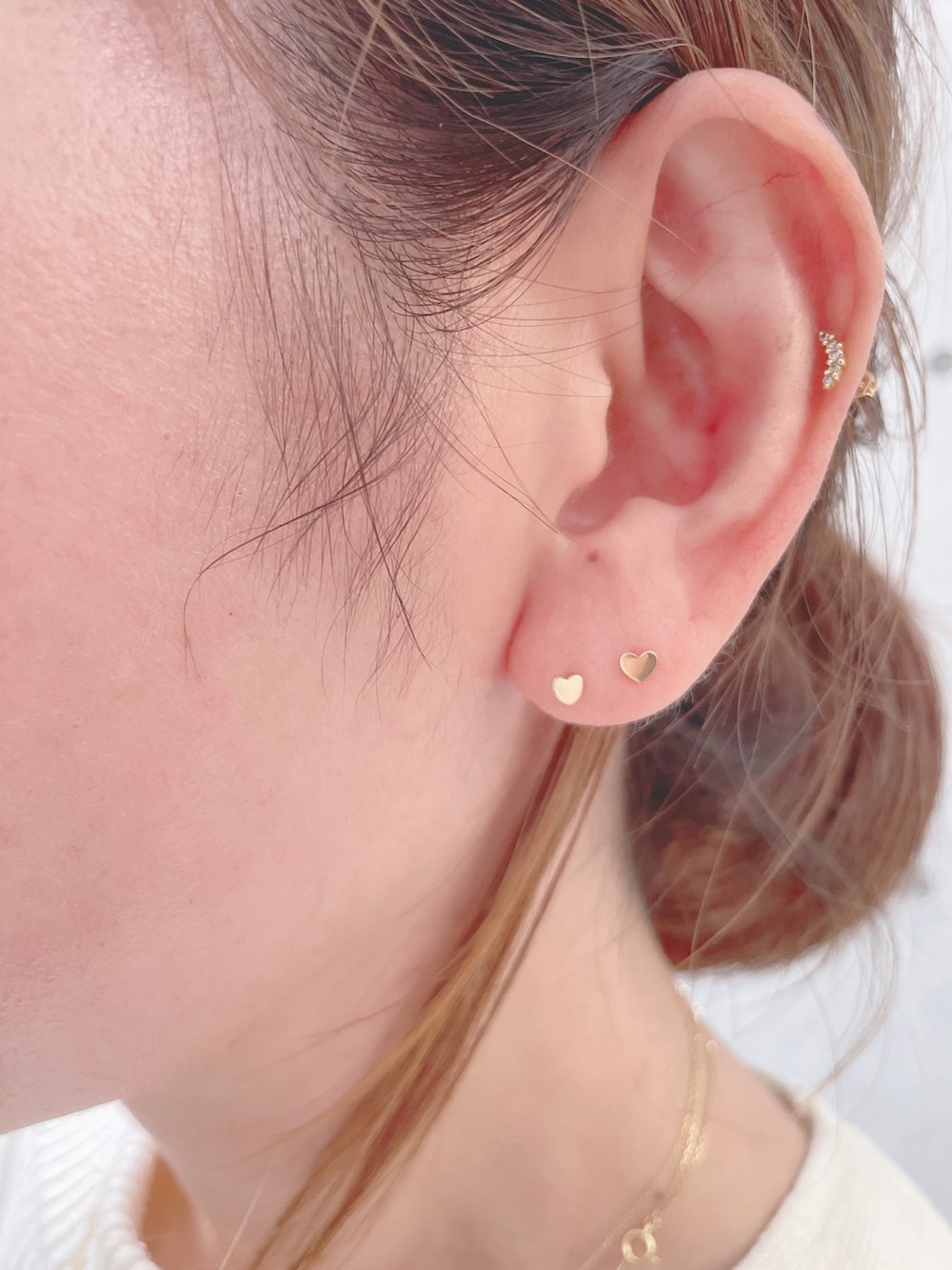 ホワイト系のベスト、ベージュ系のその他パンツ、ゴールド系のショルダーバッグを着用したレディースの秋コーディネートの4枚目の写真