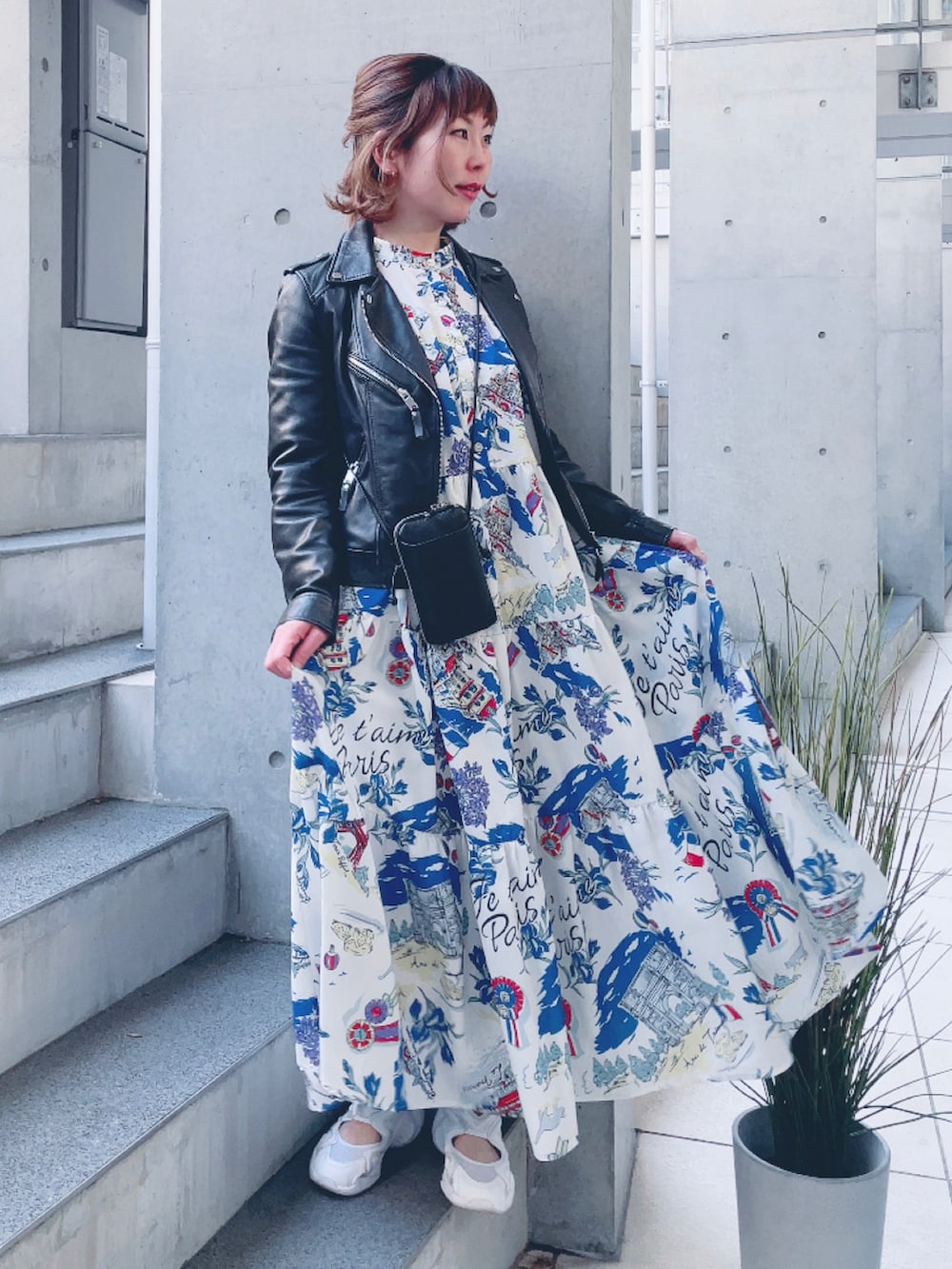 ホワイト系のワンピース、ブラック系のライダースジャケット、ホワイト系のスニーカーを着用したレディースの春コーディネートの2枚目の写真