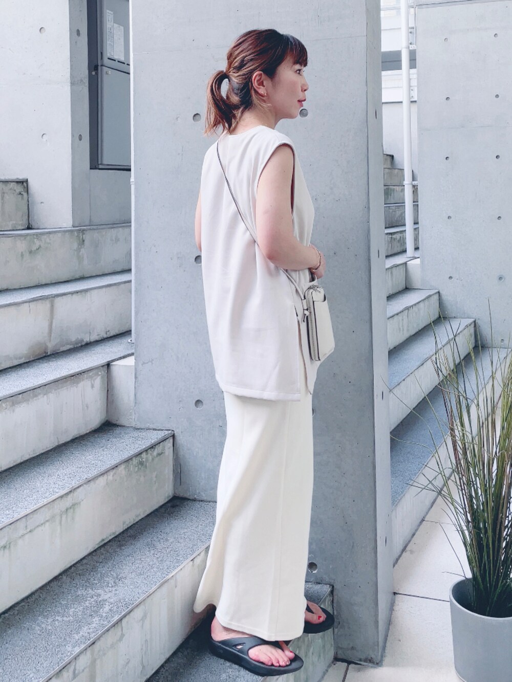 ホワイト系のスカート、ベージュ系のベスト、ホワイト系のタンクトップを着用したレディースの夏コーディネートの2枚目の写真