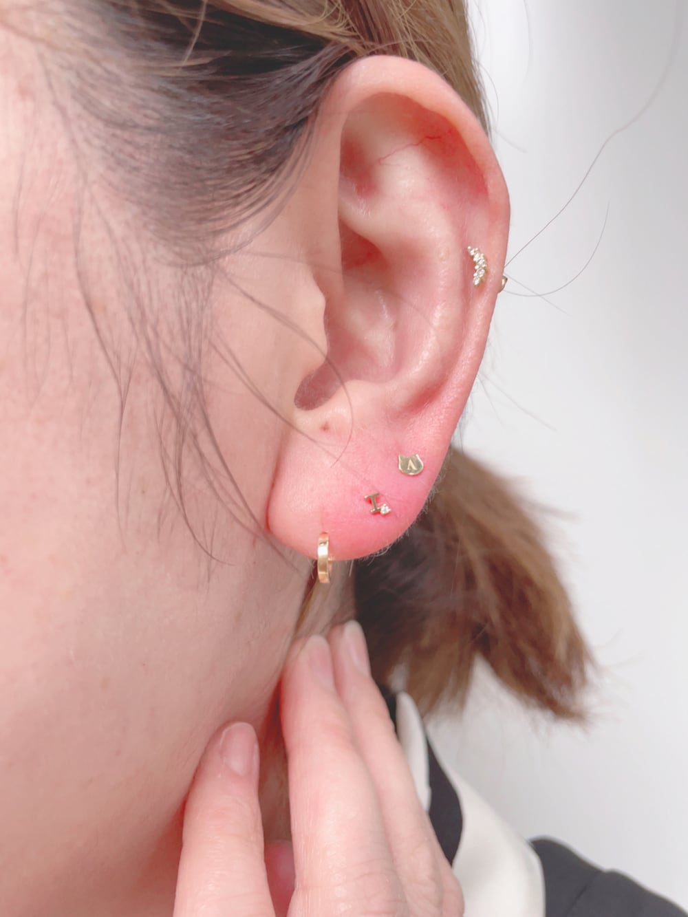 ブラック系のベスト、ホワイト系のシャツワンピース、ベージュ系のスニーカーを着用したレディースの春コーディネートの4枚目の写真