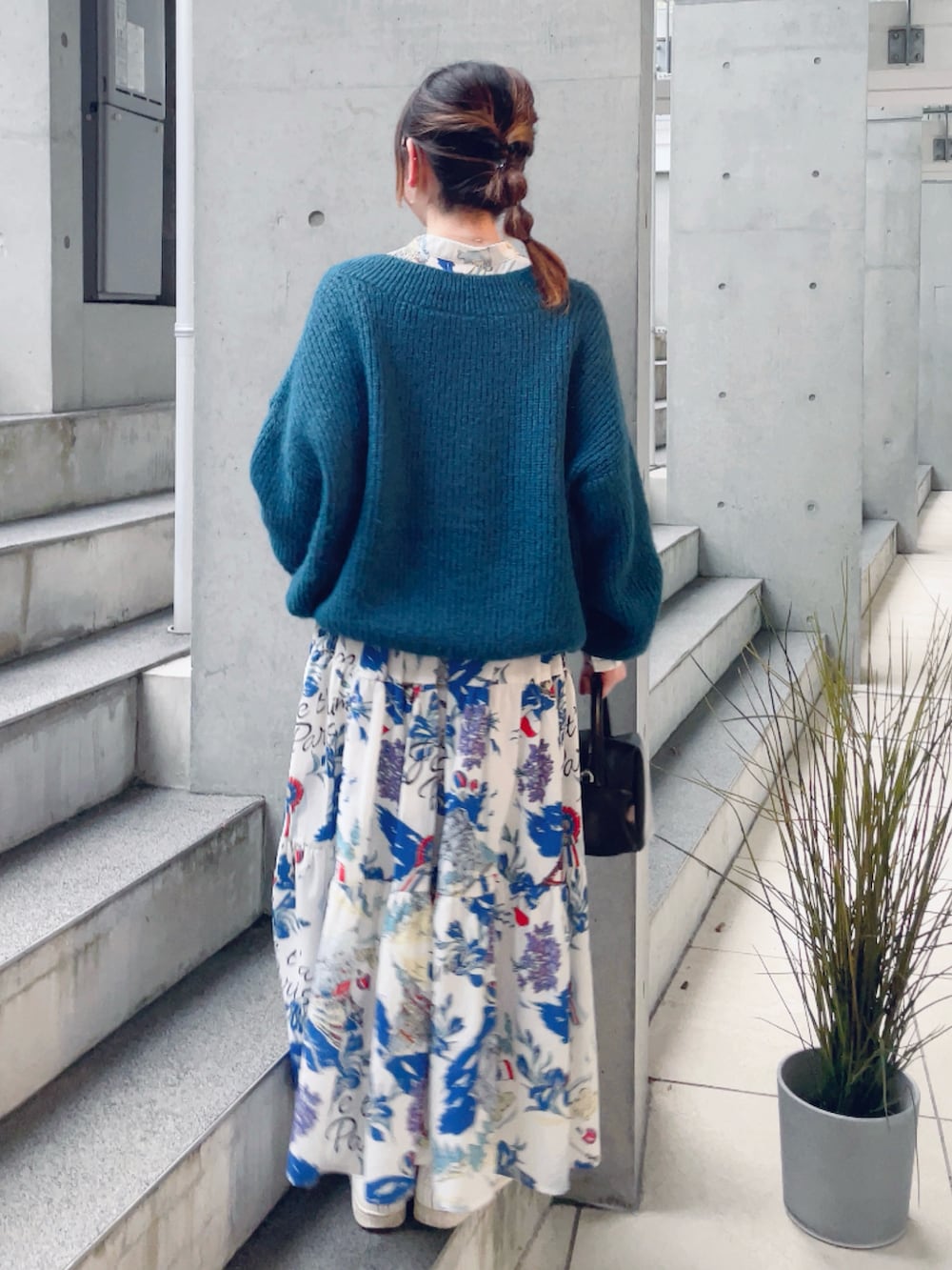 ホワイト系のワンピース、ブルー系のニット/セーター、ブラック系のハンドバッグを着用したレディースの冬コーディネートの3枚目の写真