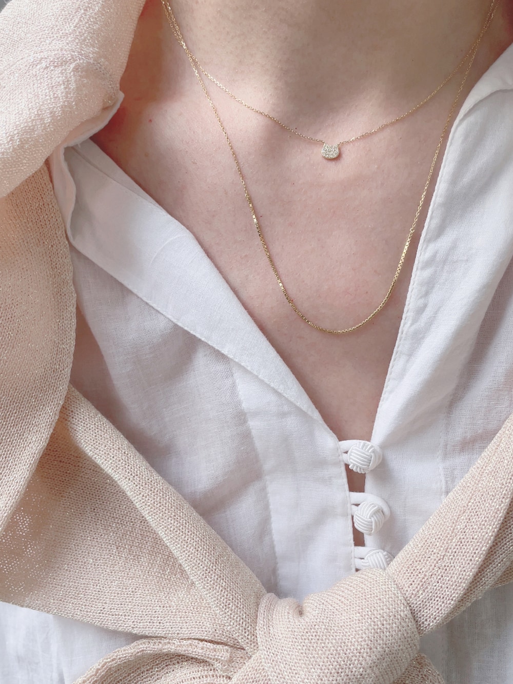 ホワイト系のワンピース、ベージュ系のパンプス、ピンク系のパンツを着用したレディースの春コーディネートの4枚目の写真