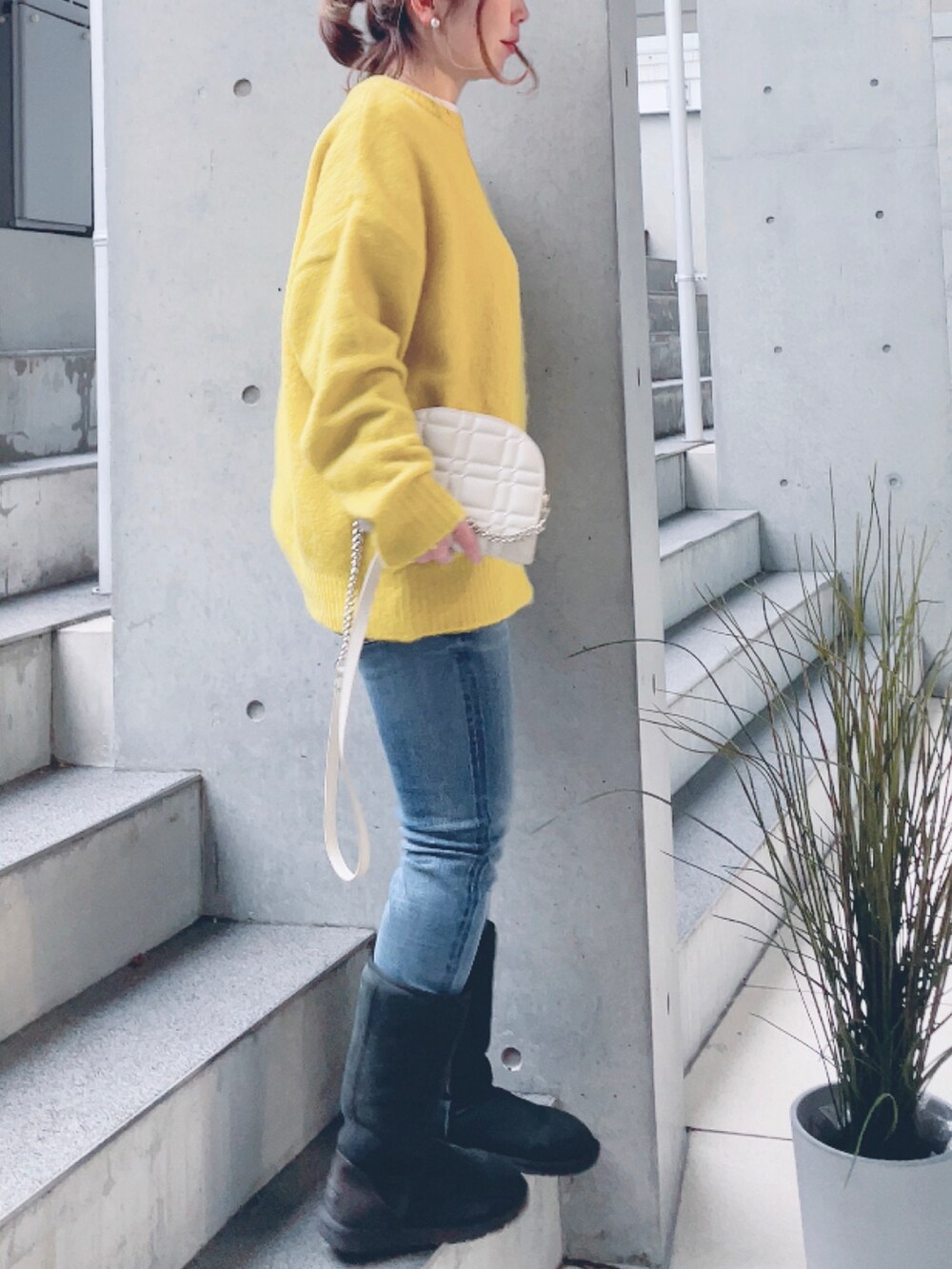 ブルー系のデニムパンツ、イエロー系のニット/セーターを着用したレディースの冬コーディネートの2枚目の写真