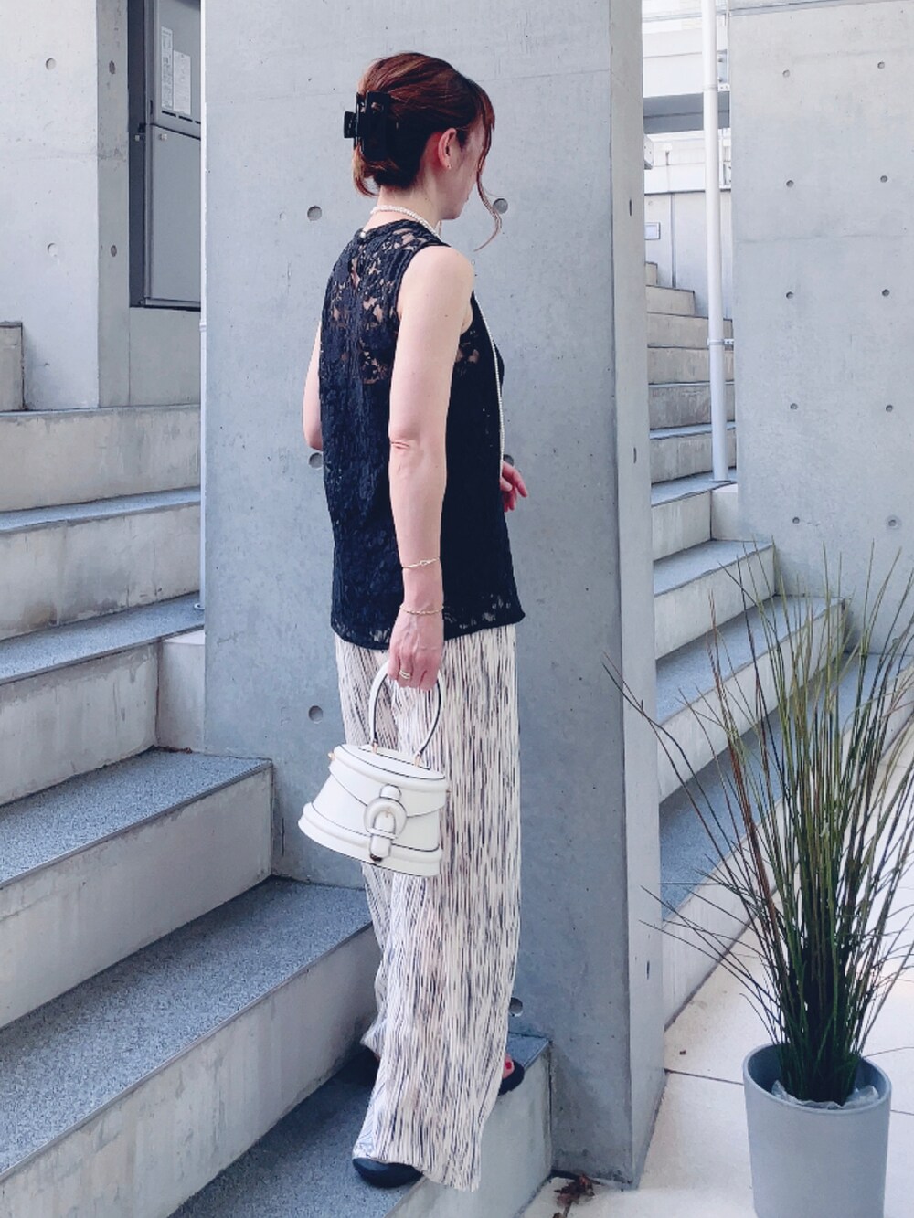 ベージュ系のその他パンツ、ホワイト系のバッグ、ブラック系のサンダルを着用したレディースの夏コーディネートの3枚目の写真