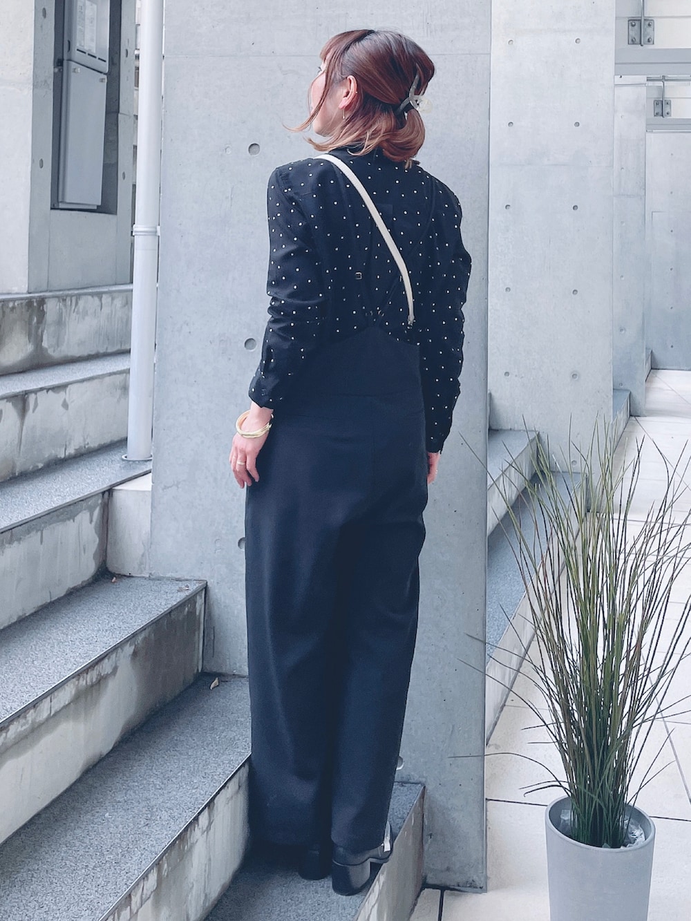 ブラック系のつなぎ/オールインワン、ゴールド系のショルダーバッグ、シルバー系のローファーを着用したレディースの冬コーディネートの4枚目の写真