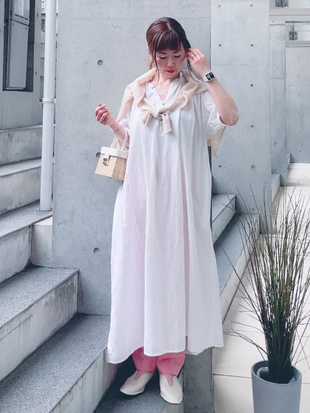 ホワイト系のワンピース、ベージュ系のパンプス、ピンク系のパンツを着用したレディースの春コーディネートの2枚目の写真