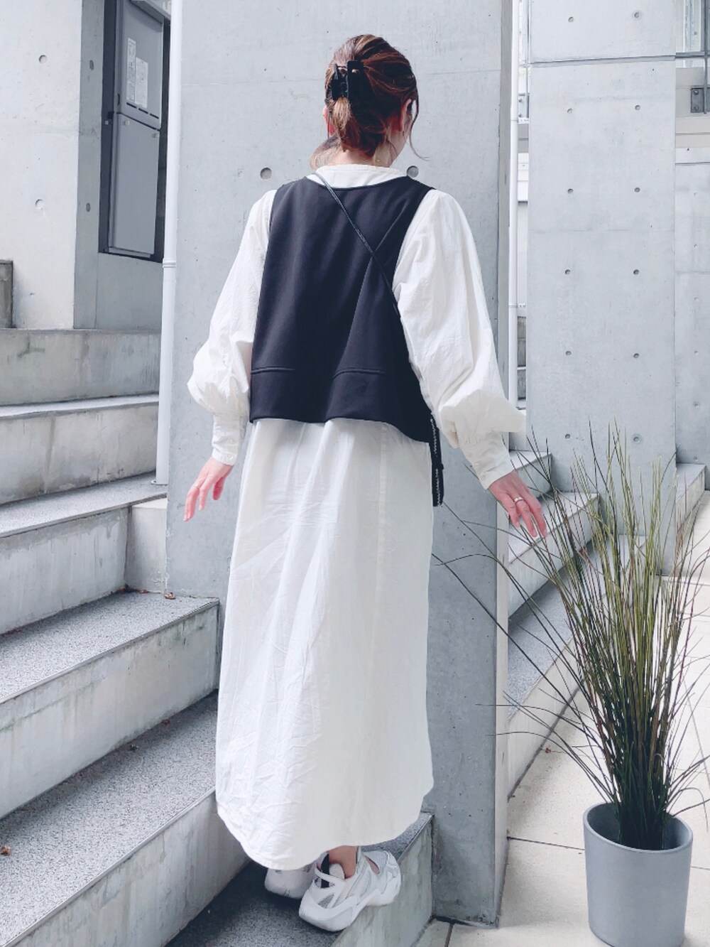 ホワイト系のワンピース、ホワイト系のスニーカー、ブラック系のポーチを着用したレディースの春コーディネートの3枚目の写真