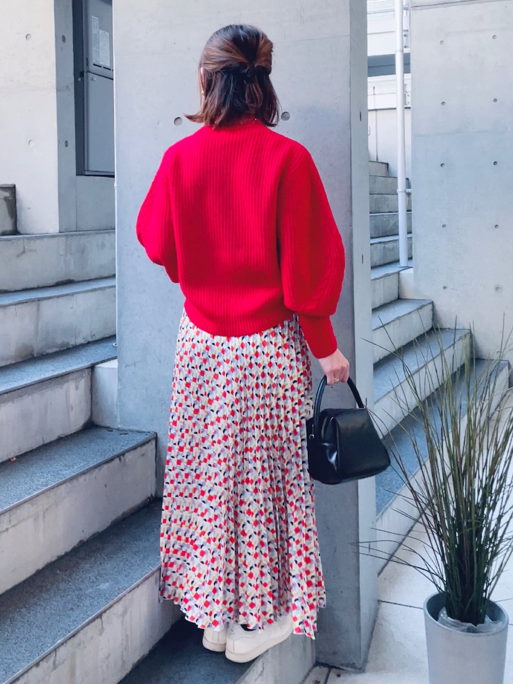 ブラック系のハンドバッグ、その他のスカート、ベージュ系のスニーカーを着用したレディースの冬コーディネートの3枚目の写真