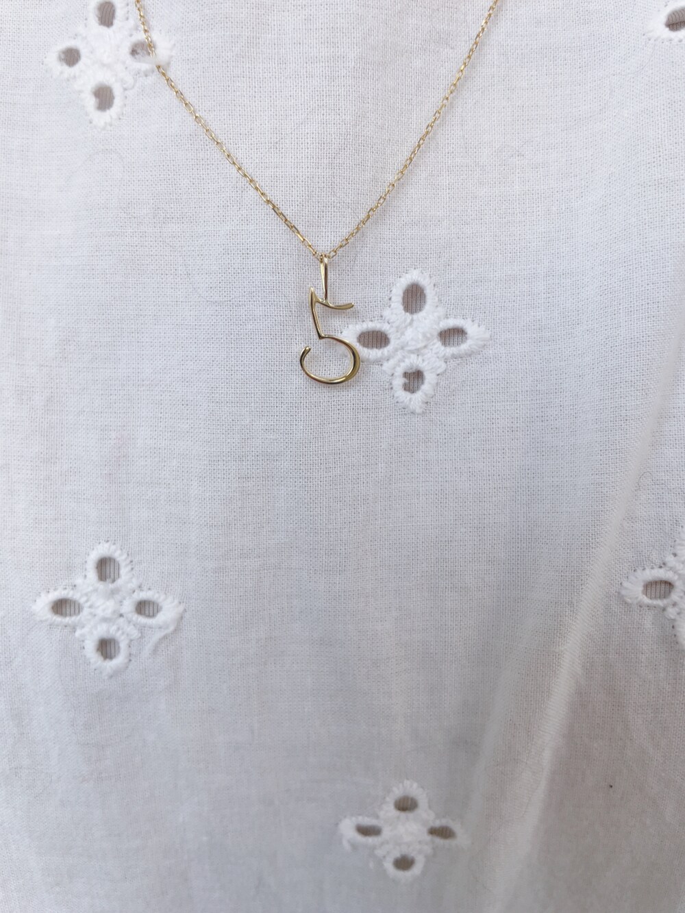 ホワイト系のワンピース、ブラック系のブルゾン、ブラック系のハンドバッグを着用したレディースの春コーディネートの4枚目の写真