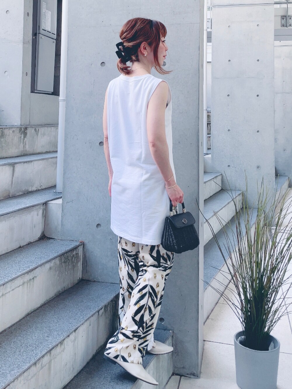 ホワイト系のタンクトップ、ベージュ系のその他パンツ、ブラック系のかごバッグを着用したレディースの夏コーディネートの4枚目の写真