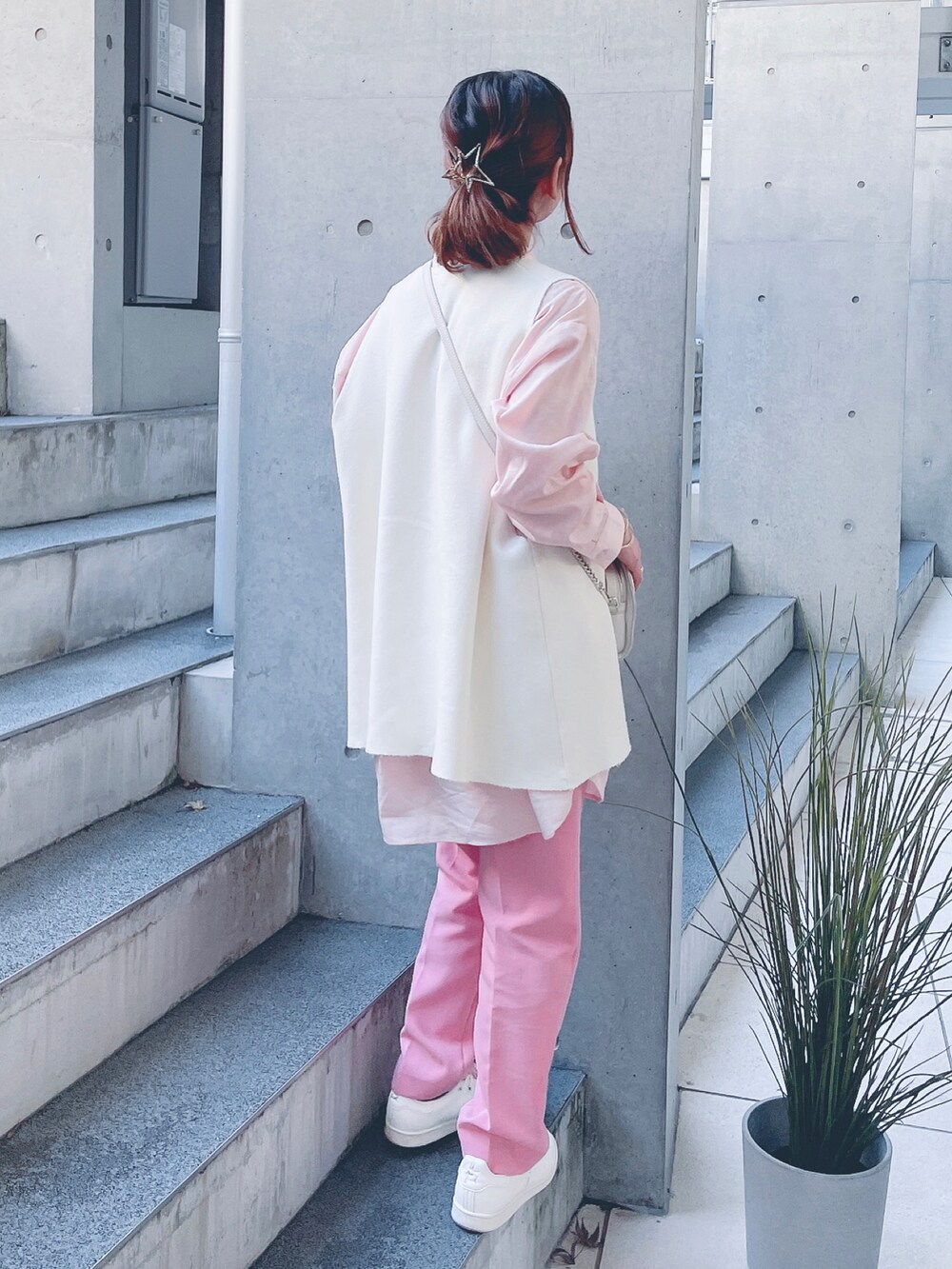 ピンク系のシャツ/ブラウス、ホワイト系のベスト、ピンク系のパンツを着用したレディースの秋コーディネートの3枚目の写真
