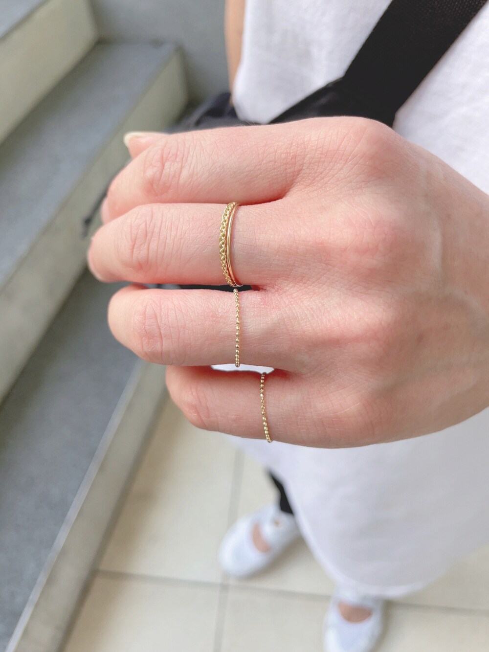 ホワイト系のタンクトップ、ホワイト系のスニーカー、ブラック系のキャップを着用したレディースの夏コーディネートの4枚目の写真